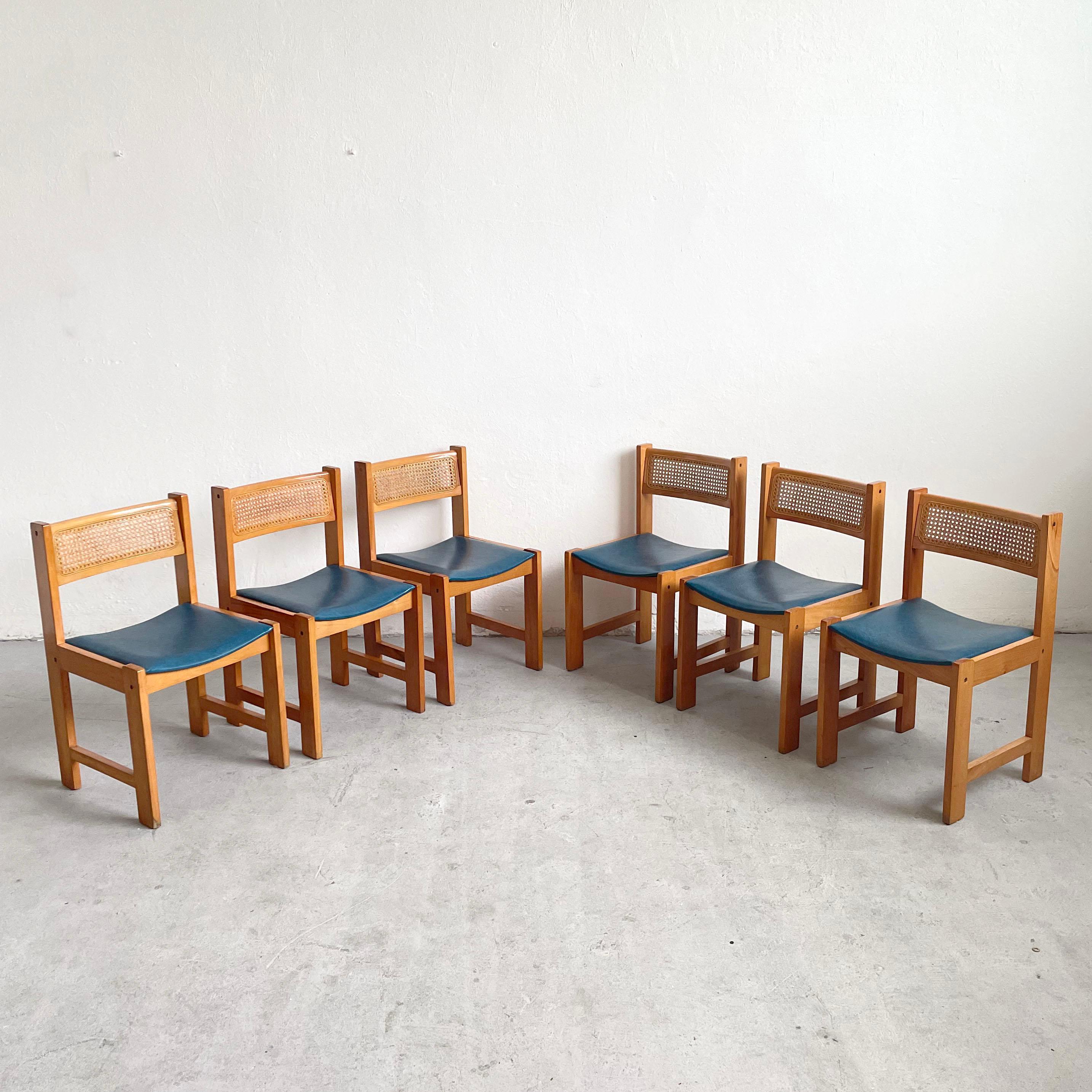 This is a set of 6 vintage dining chairs.

Beautiful vintage mid century wooden dining chair feature blue vinyl seat with dark patches and a cane backrest. They have a very simple and elegant modernist form. 

The chairs have original finish which