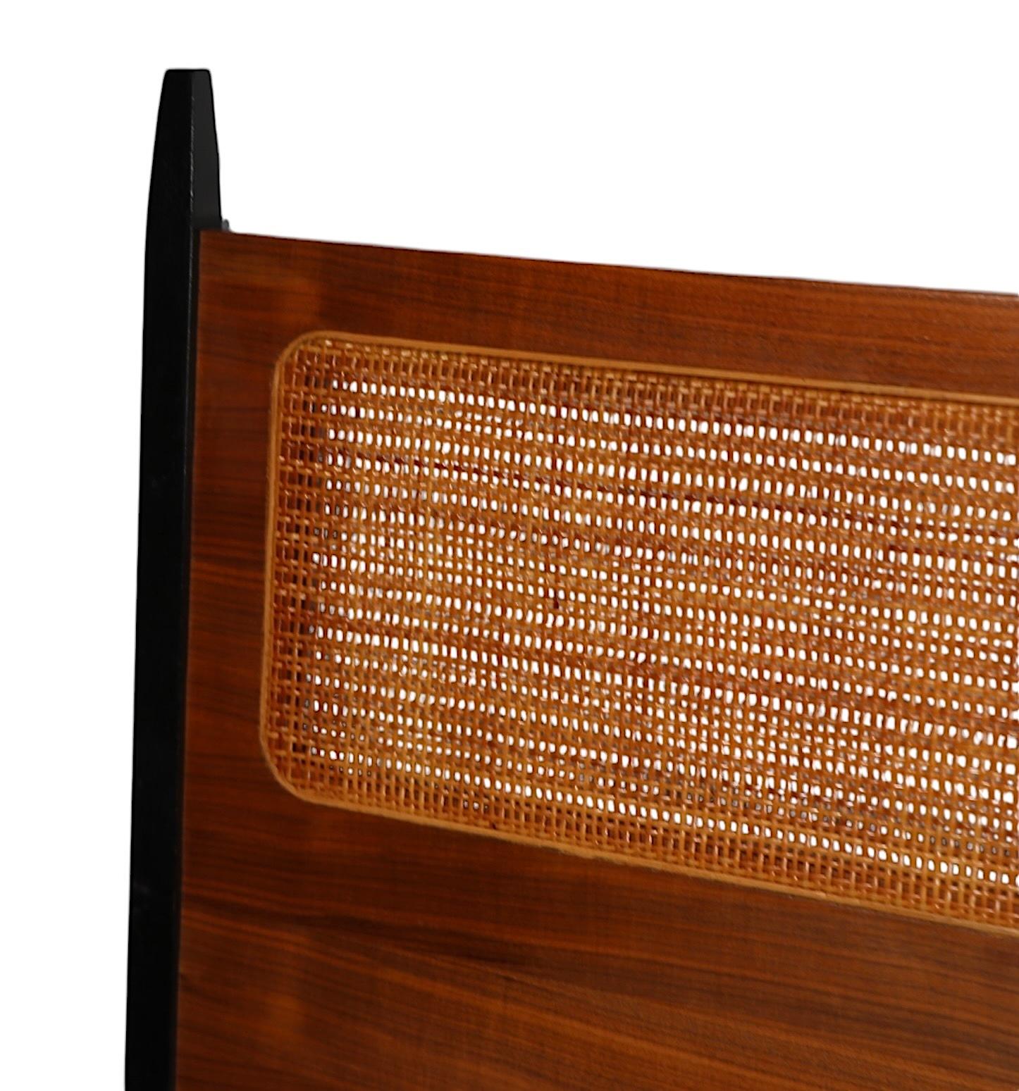 Chic architectural Mid Century full size headboard, design attributed to Milo Baughman for Directional c. 1950/70's. The headboard features a caned insert center panel, surrounded by a vibrant veneered frame, with dramatic black posts at the
