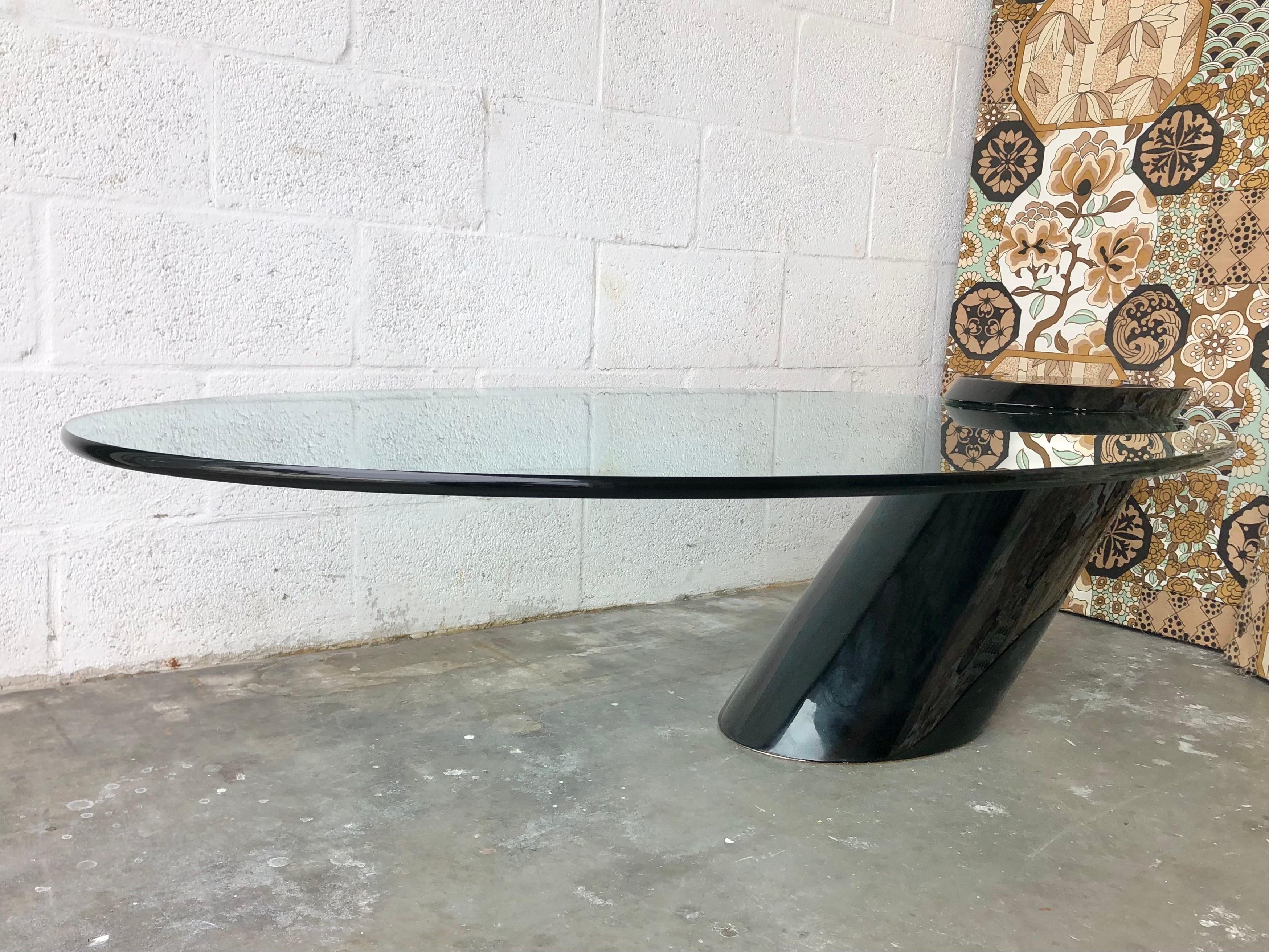 Vintage mid-century Cantilever coffee / coctail table attributed to J Wade Beam for Breuton. Circa 1970s. 
Features a black polished base that protrudes from the floor at a 45 degree angle with cantilevered oval glass top. The base is perfectly