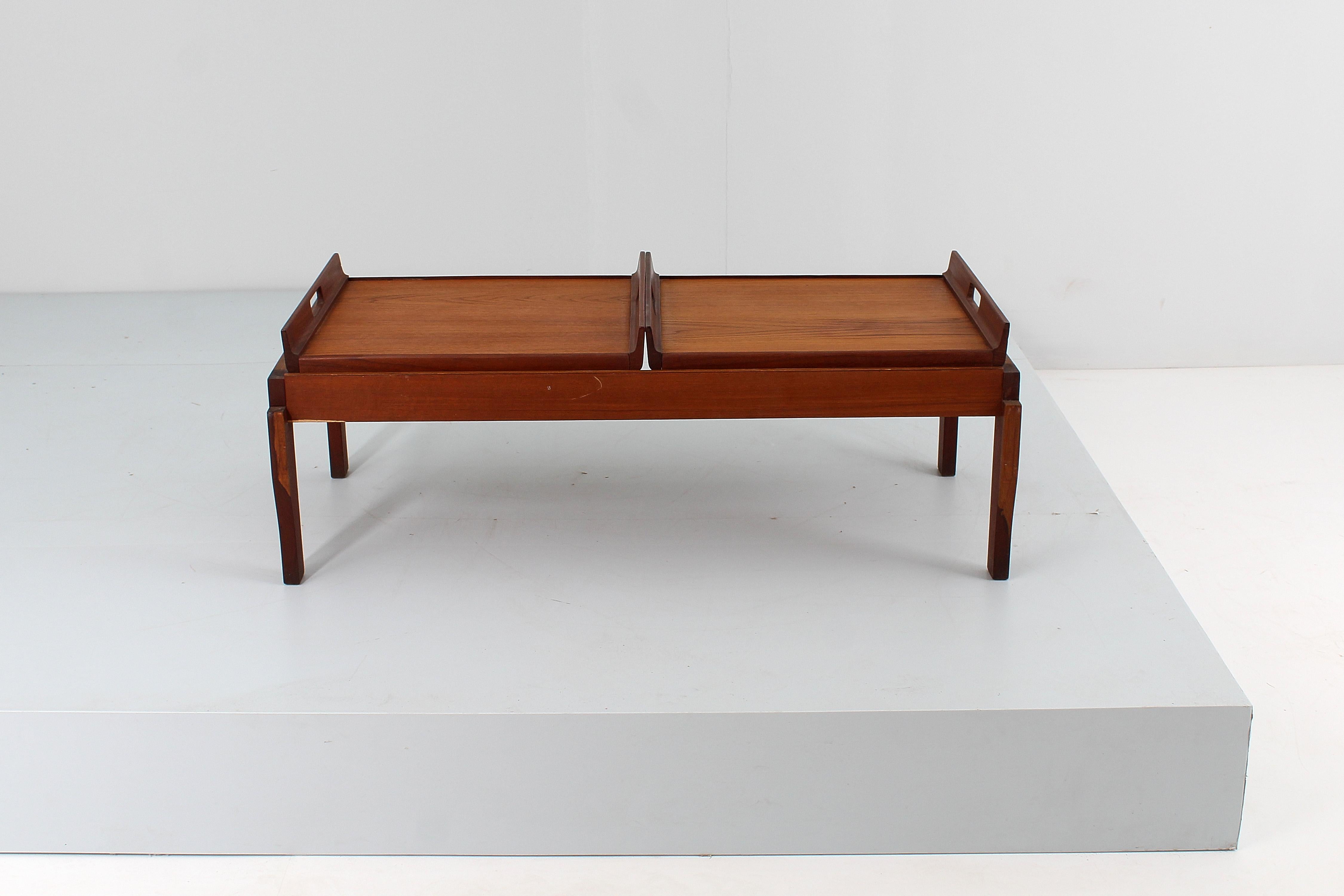 Large coffee table in teak with geometric structure and top made up of two removable trays with handles obtained through oval holes on two sides curved upwards. Design, originality and utility in this production from Cantù, Italy in the 1960s