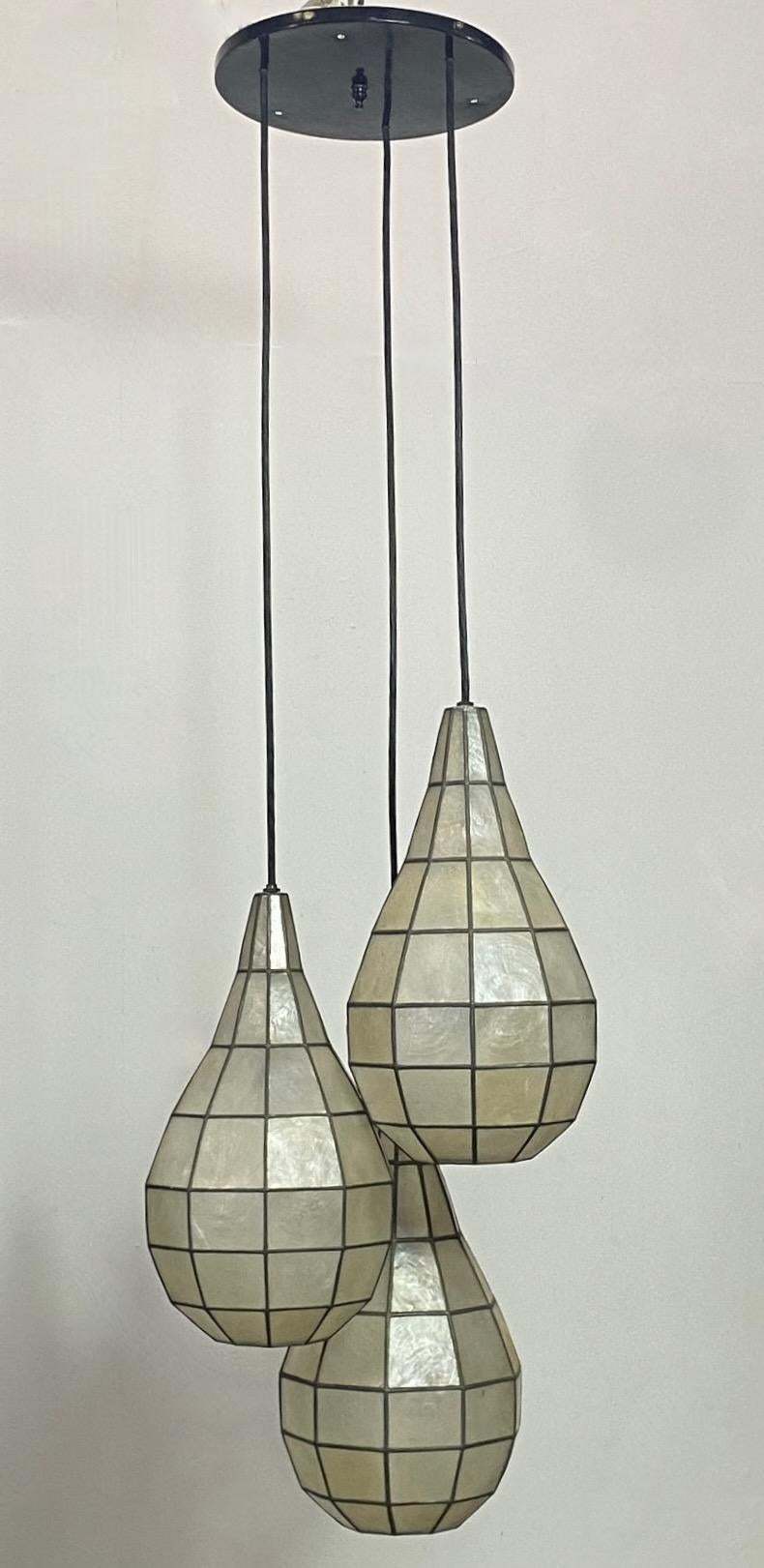 A unique Capiz shell light fixture with three hanging tear drop shape pendants.
A dramatic look that will work well with many styles of interior design.
Each shade measures 14.5 inches high.
Recently refreshed and re-wired.
American, 1950's-1960's.