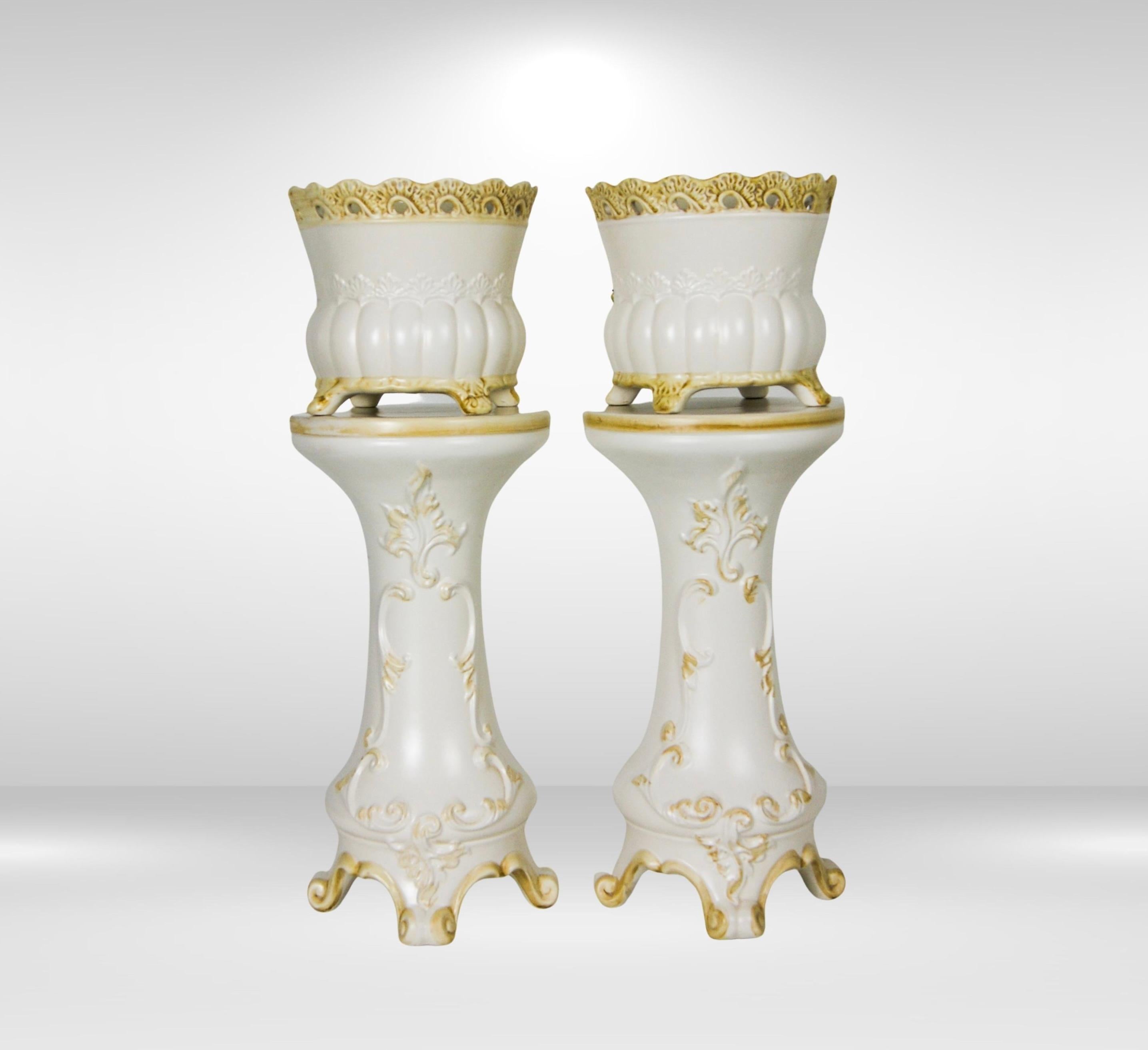 Mid-century pair of Jardiniere planters & matching tall pedestal stands by Capo di Monte Italy.
Two ceramic flower pots with two matching tall pedestal stands, in colour creamy white with pale gold baroque motif details.
Both jardinieres and