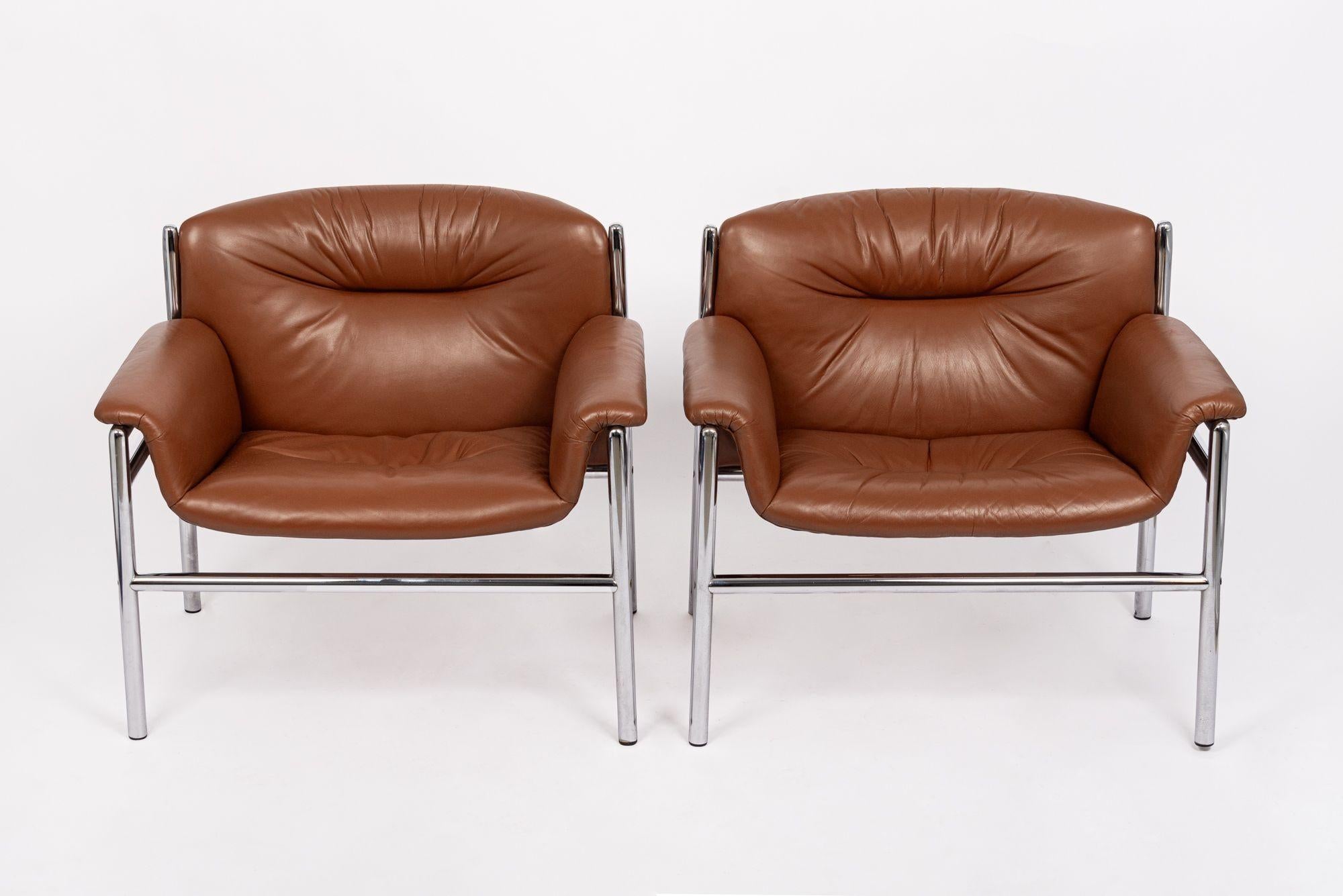 This stunning pair of vintage mid century modern lounge chairs were produced by Stendig circa 1960. These matching lounge chairs are exceptionally well-built and feature gorgeous caramel brown leather upholstery, extra wide seats and double-filled