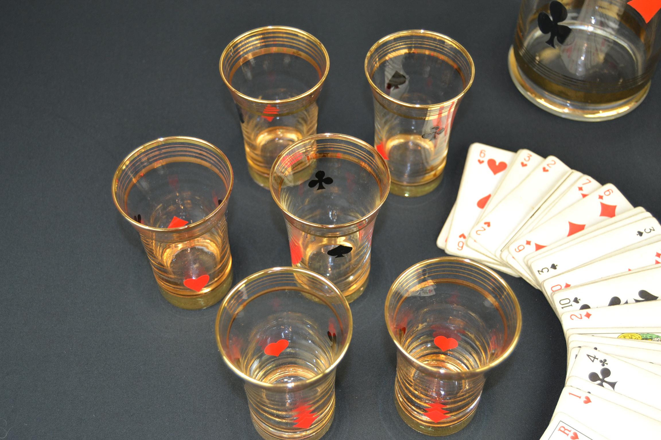 Midcentury vintage card game decanter set
consisting of a decanter with six small and six large glasses.
As well the glasses as the decanter have the red and black signs of a card game:
clubs, diamonds, hearts and spades, all with golden borders