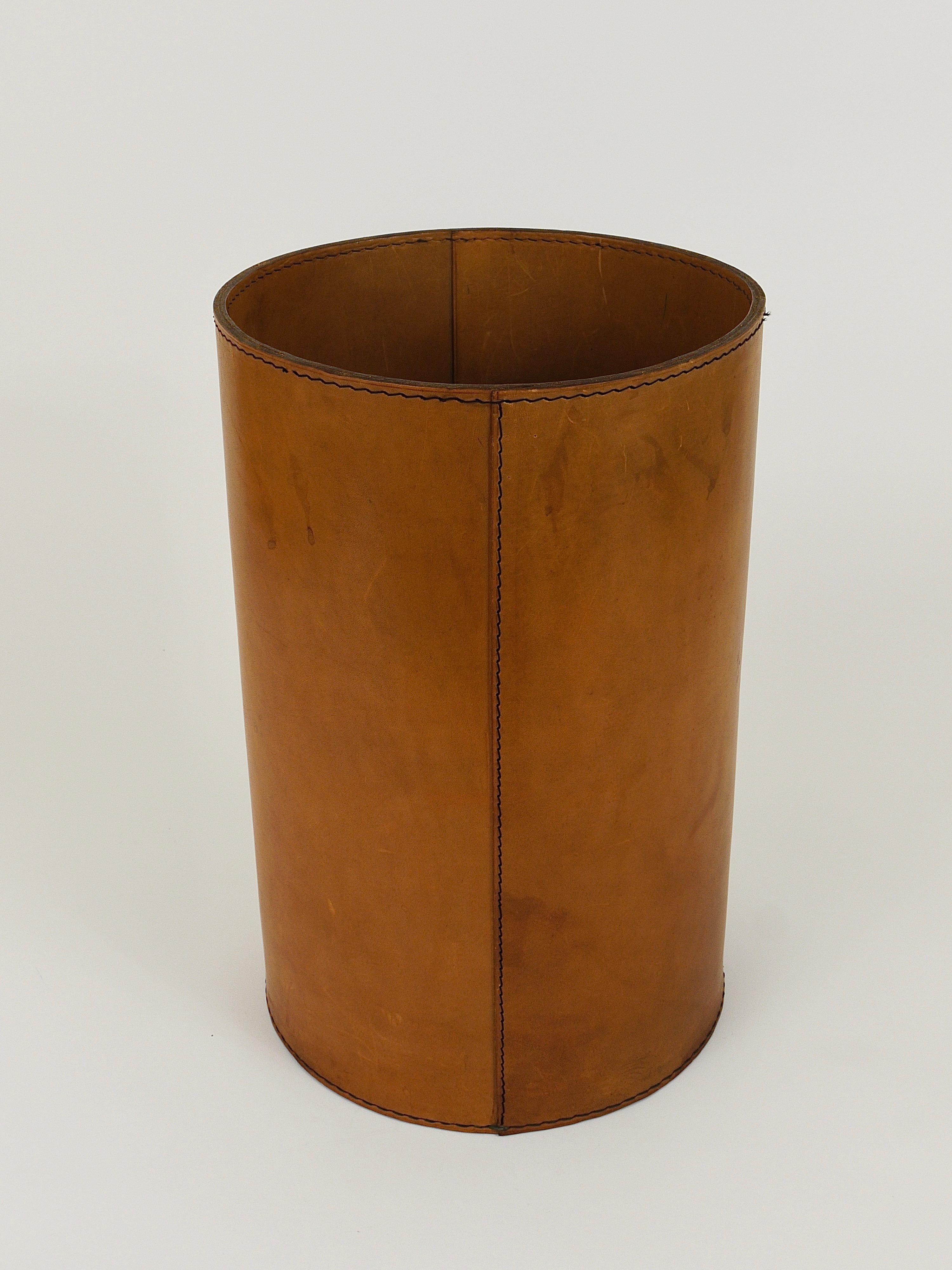 A beautiful and elegant, vintage Mid-Century Modern paper basket / paper bin from the 1950s. Designed an executed by by Werkstätte Carl Aubock, Vienna / Austria. Handmade and hand-sewn from thick honey / cognac brown leather. In very good condition