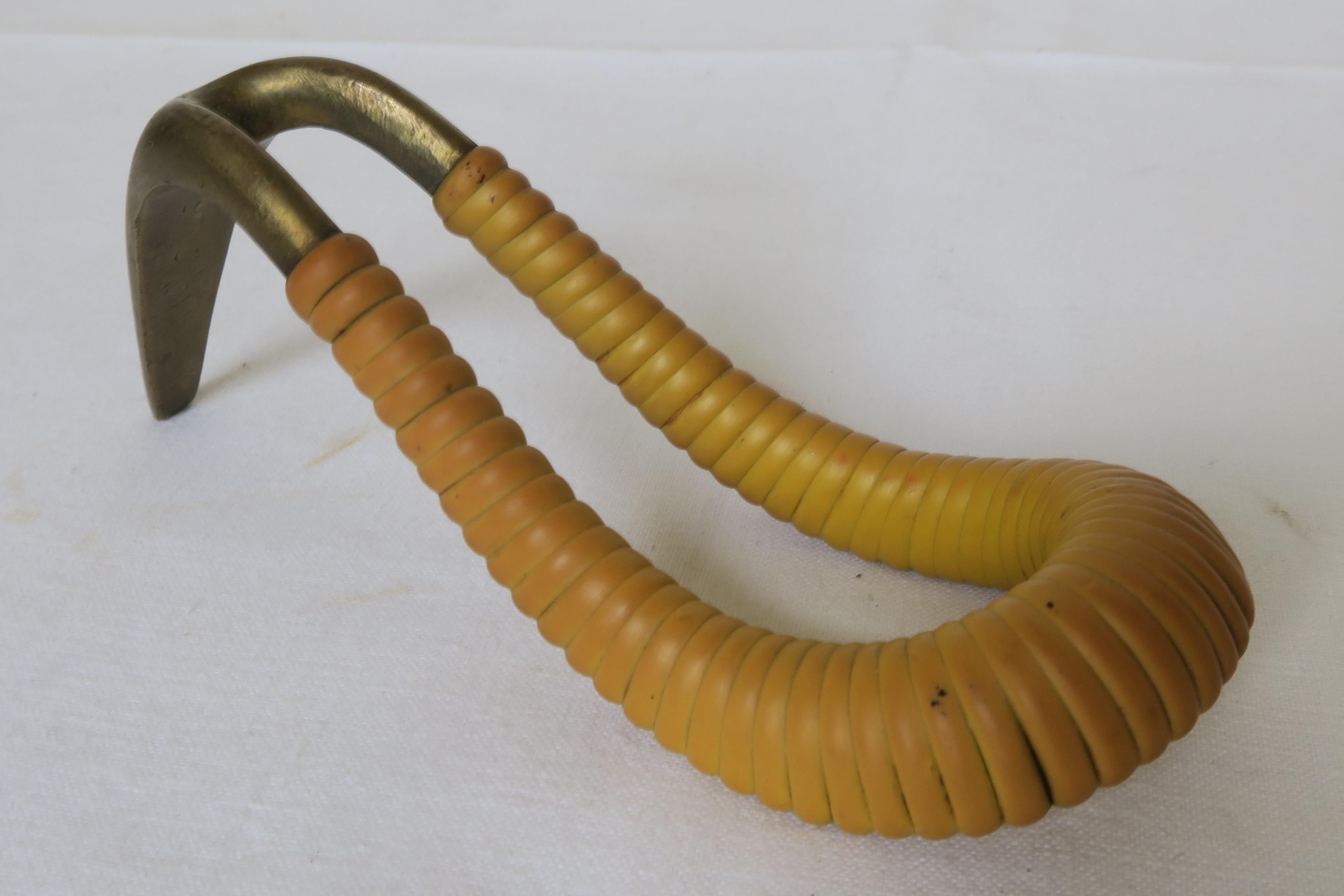For sale is a beautiful decorative pipe rest. It was hand-crafted from brass and has been embellished with mustard yellow covering, that has been wrapped partly around the brass to prevent it from heating up or getting scorched. It was designed by