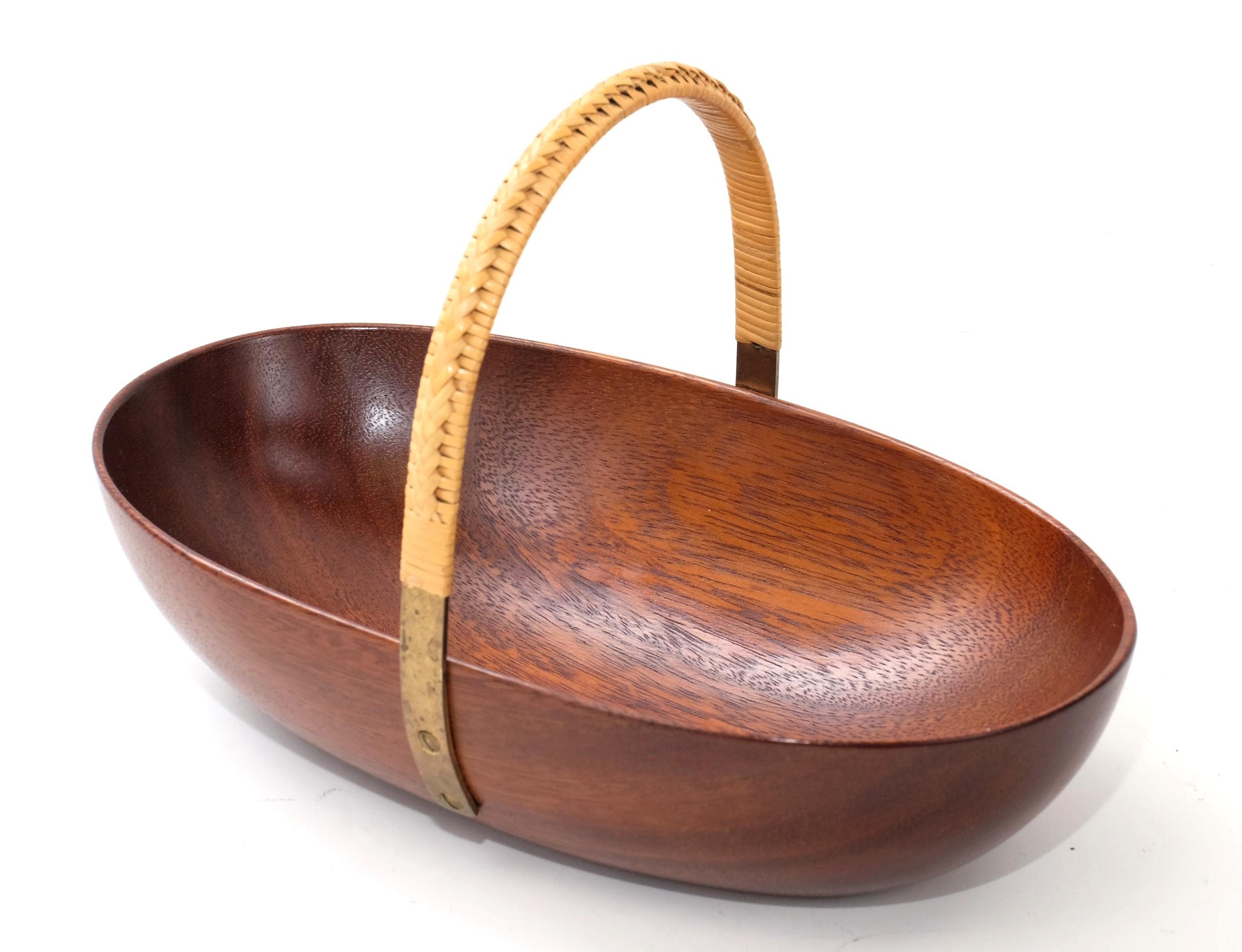 Original 1950s bowl element made by of solid teak wood and brass loop with rattan at the top for carrying. This fantastic piece was designed by Carl Auböck in the 1950s, and handcrafted in his Workshop in Vienna, Austria in the 1950s. 

It is a very