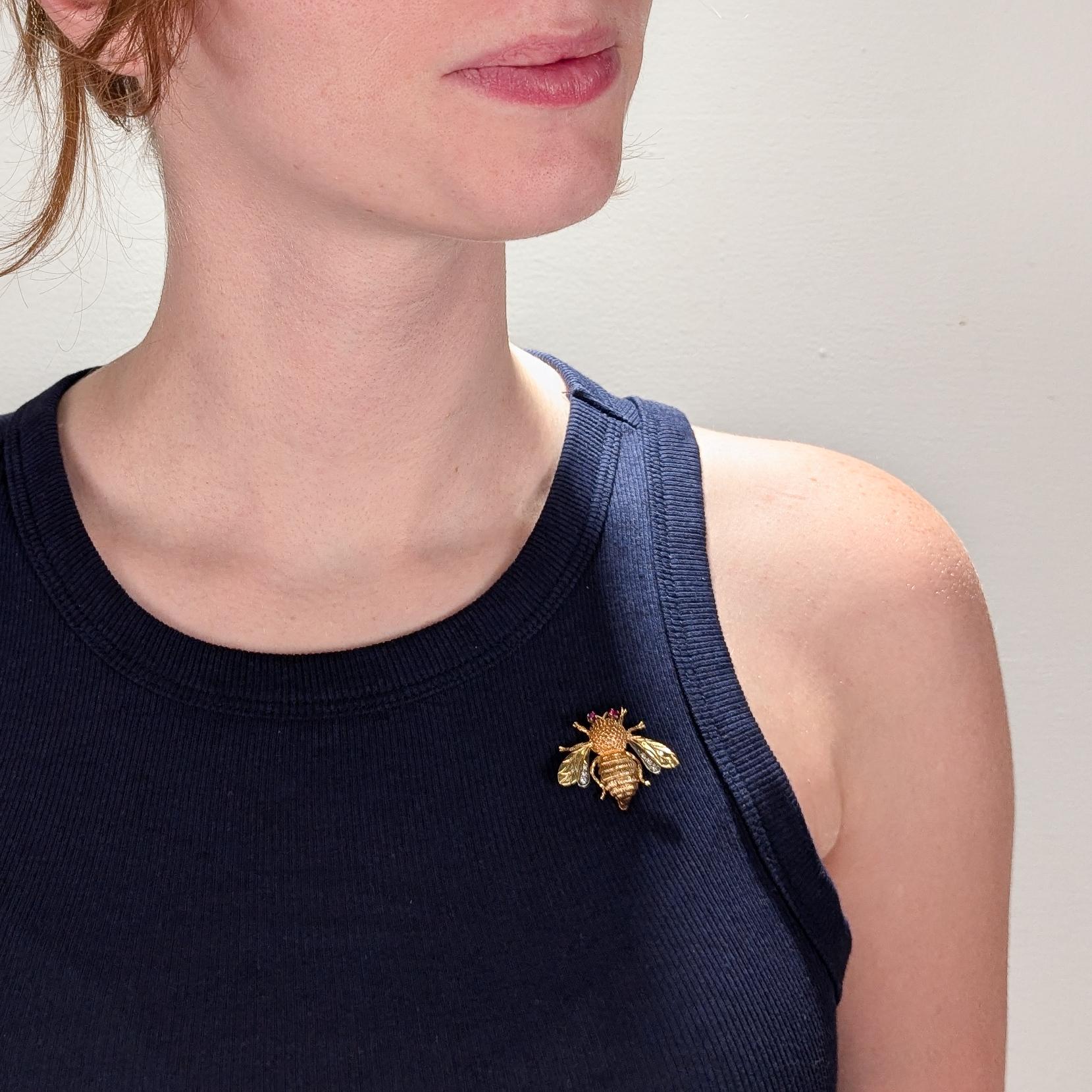 A fine signed figural bee brooch.

In in form of a bumble bee with a fuzzy thorax and large abdomen.

By Carl D Lindstrom & Son, Mid-Century jewelers from Los Angeles, California.

In 14k yellow and white golds.

Prong-set with ruby eyes and round