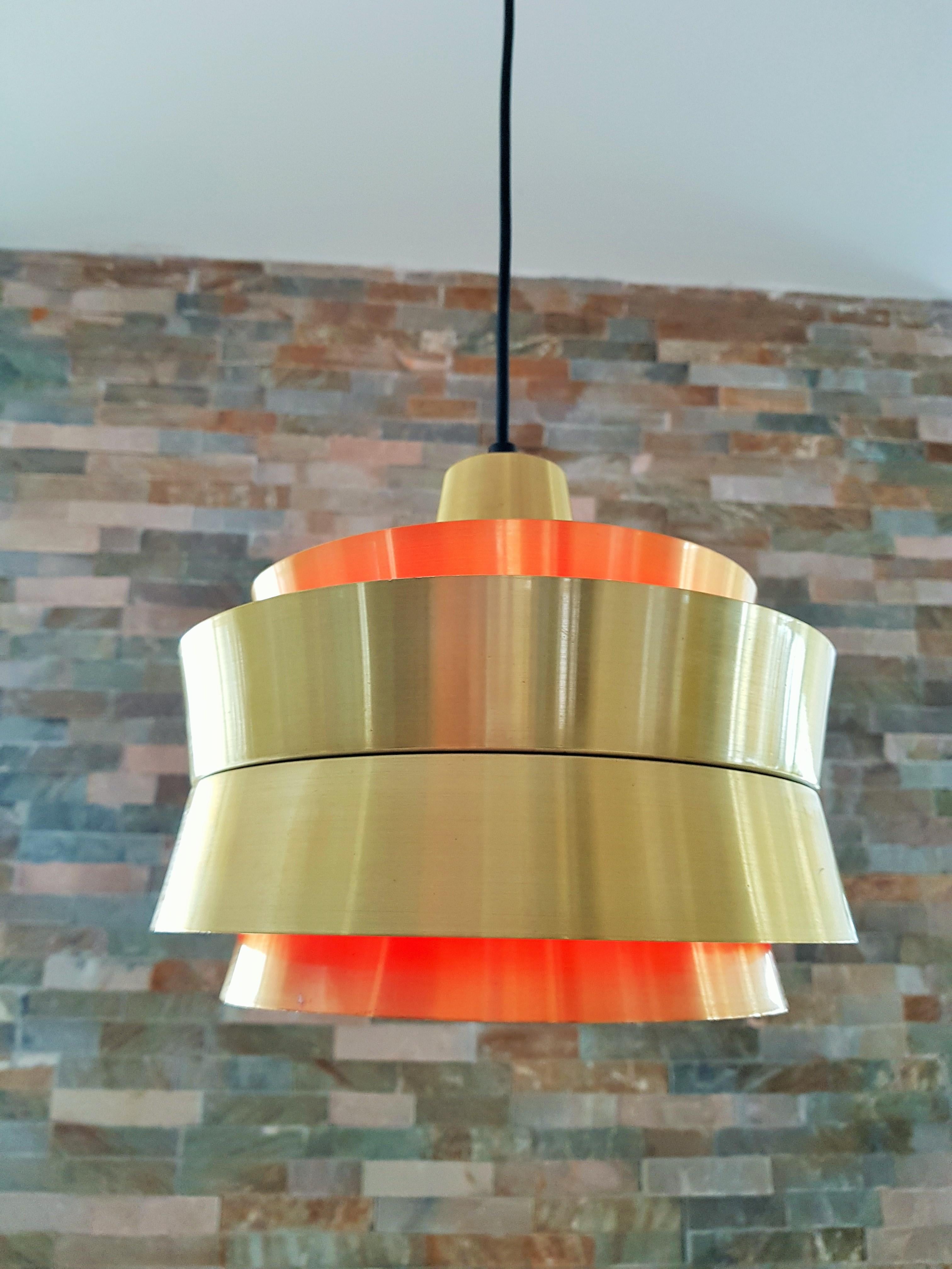 Pendant light designed by Carl Thore and made in Sweden by Granhaga Metal lindustries. This lamp have aluminum shades with a brushed brass finish on the outside, orange lacquer on the inside, which makes beautiful glow when lit.

re-wired.


  
