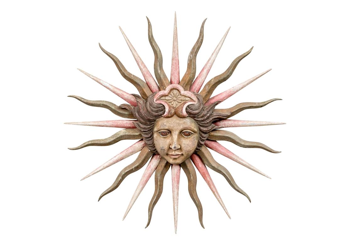 Eine auffällige Mid Century Sunburst mit einem zentralen gütigen Göttin Art Gesicht mit gestaffelten roten und grauen gebogenen Strahlen gemalt. Sie umrahmen das hochreliefierte Gesicht mit gewelltem braunem Haar und gemalten Gesichtszügen, das eine