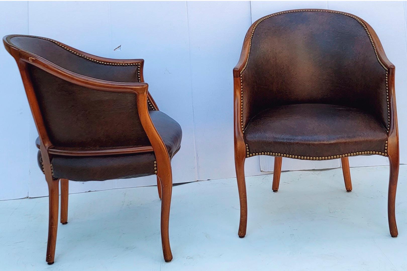 This is a handsome pair of carved fruitwood and leather tub chairs by Baker Furniture. They are marked and in very good condition. Seat ;18”. Arm;26.5”.