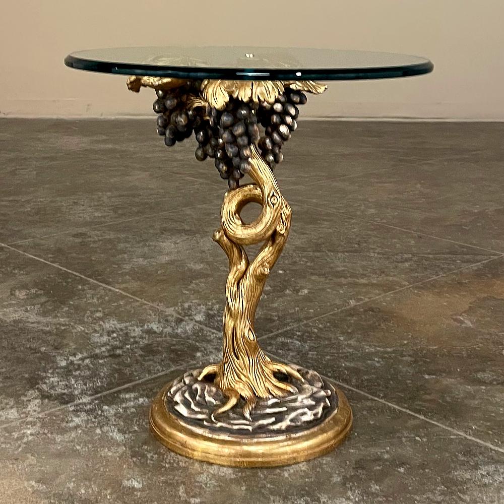 Midcentury Carved Giltwood and Glass Lamp Table will make the perfect addition to any room, but especially the wine room! Carved and gilded to depict an old-growth fully laden grapevine, the leaves splay out at the top to support the thick beveled