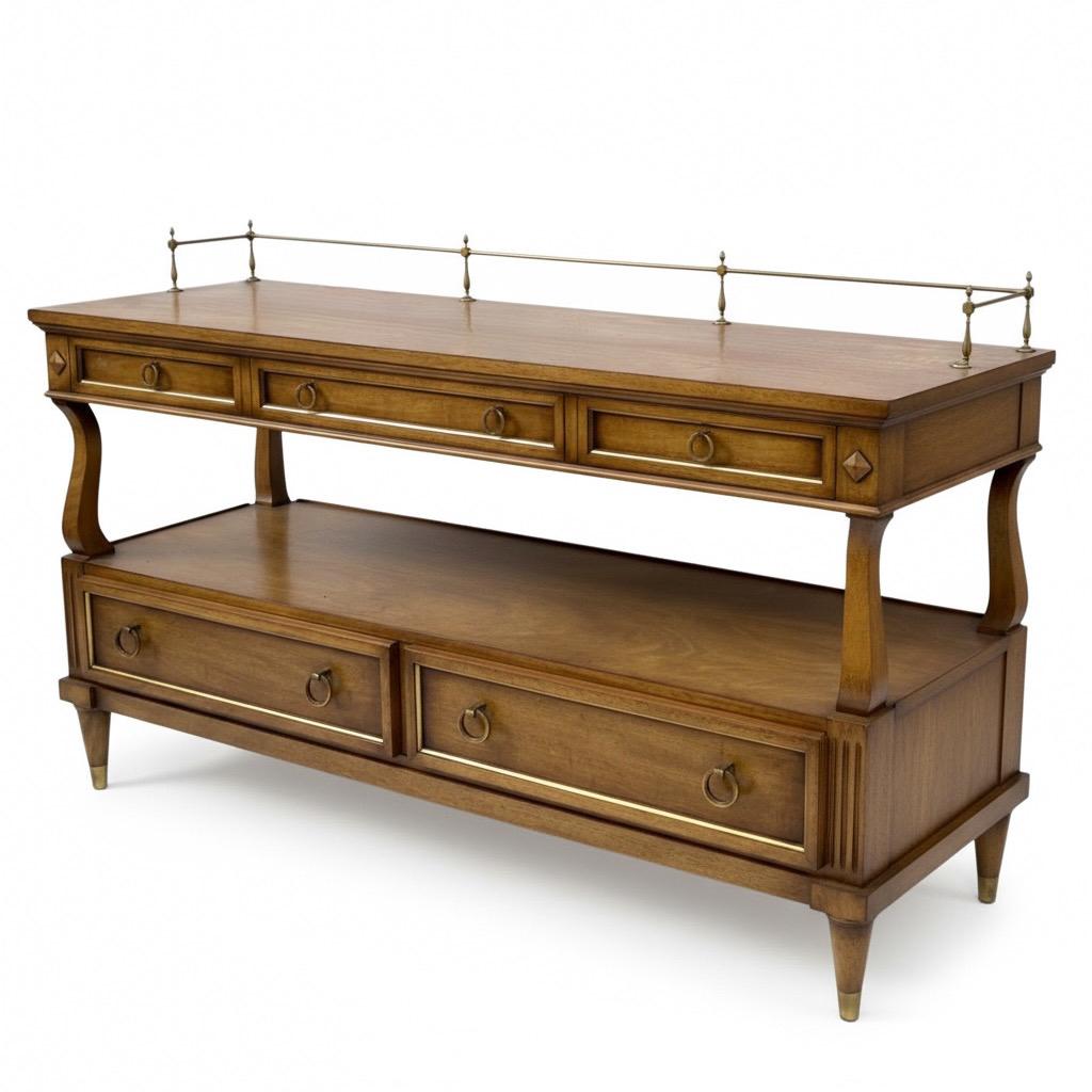 This is such a handsome and versatile piece! It is a carved mahogany two tiered server hand crafted in the USA by Karges. It has a brass gallery and gilt accents accompanied by dovetail construction. This could work from dining to bar! 