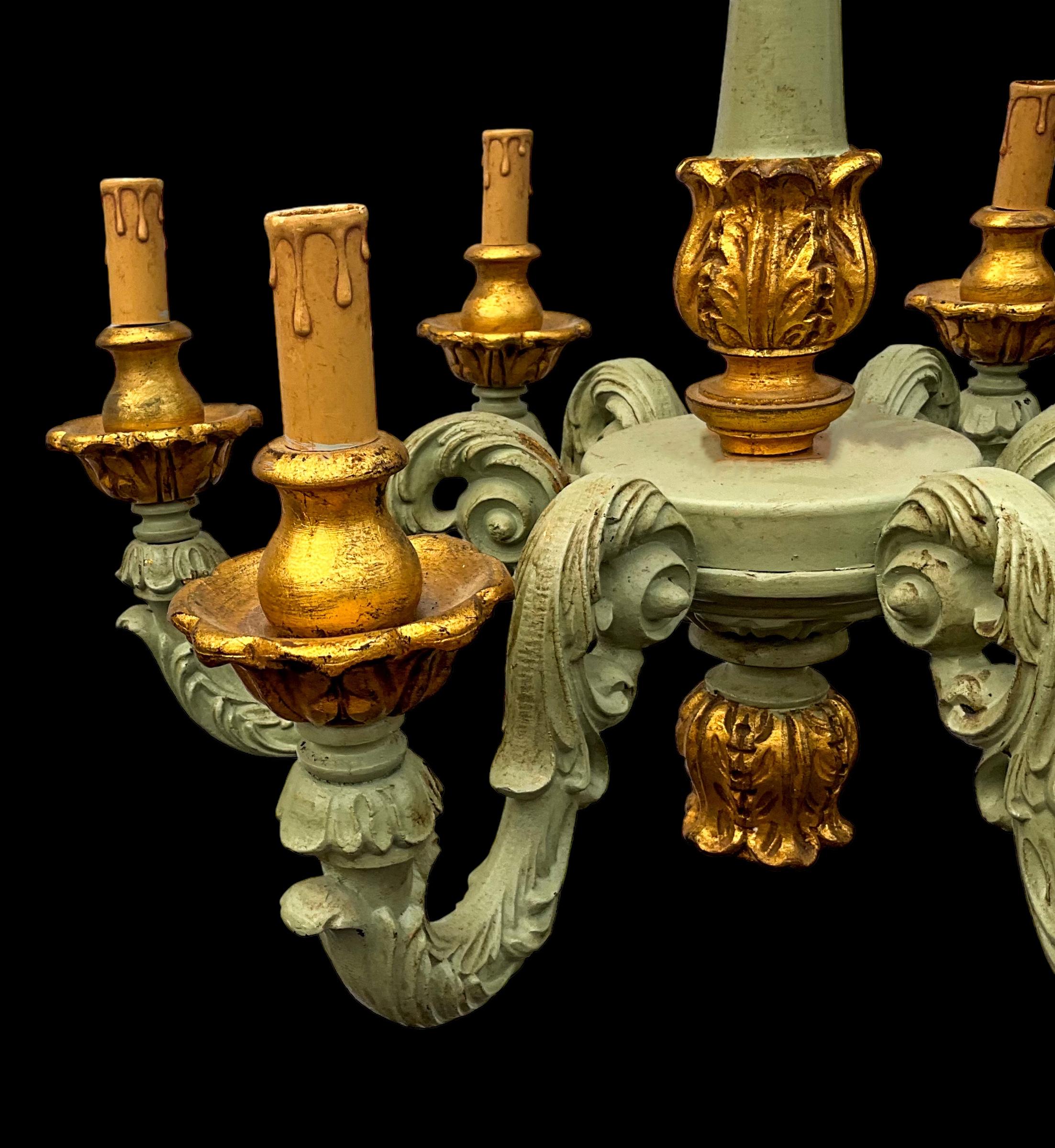 This is an Italian carved and painted chandelier with gilt accents. It has Rococo styling and is unmarked. The piece has six arms.