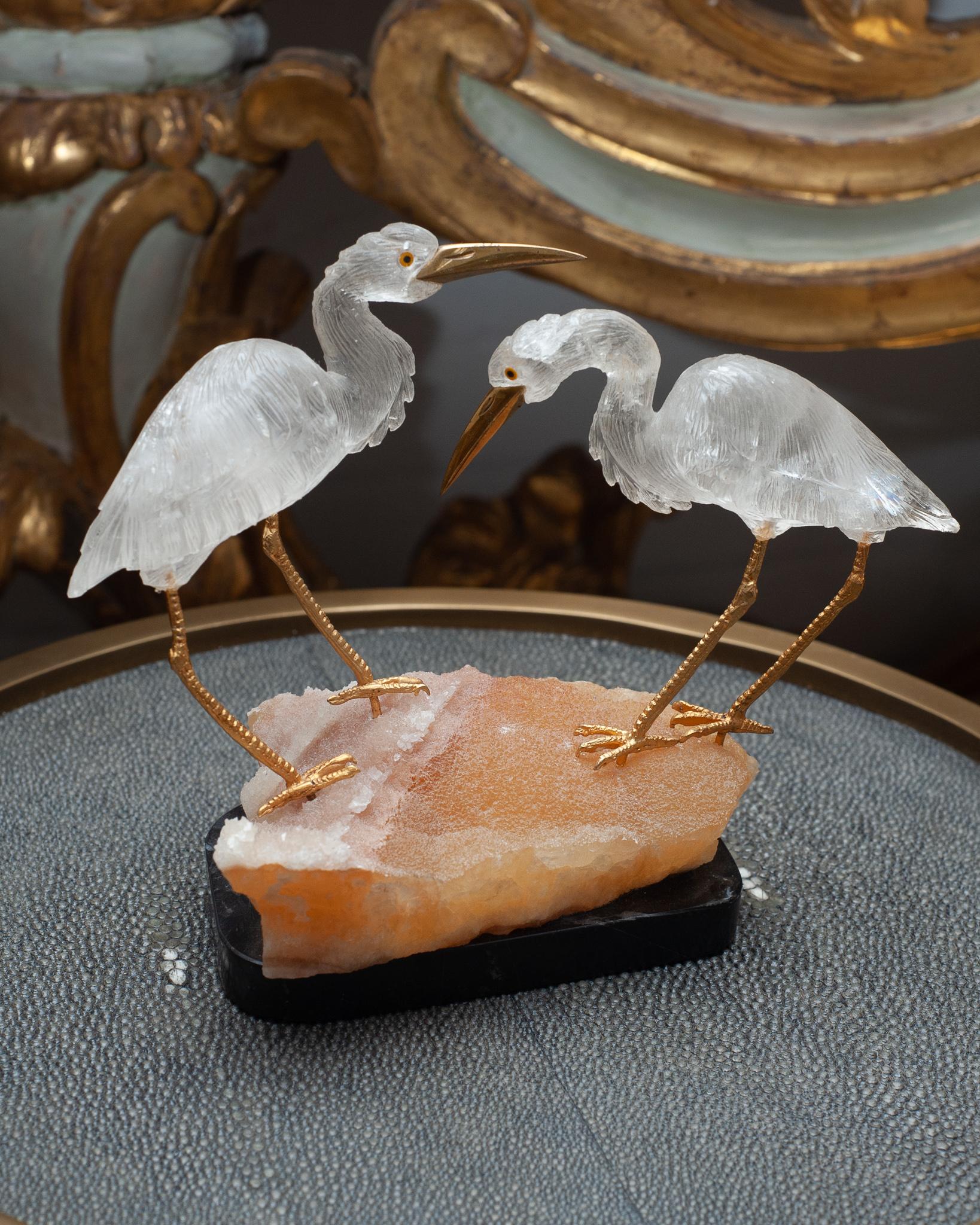 A stunning mid century pair of mineral cranes, carved from quartz / rock crystal, with brass legs and beaks, and mounted on a base of orange calcite and black marble. An exceptional and rare quality carving - this marriage of craftsmanship and