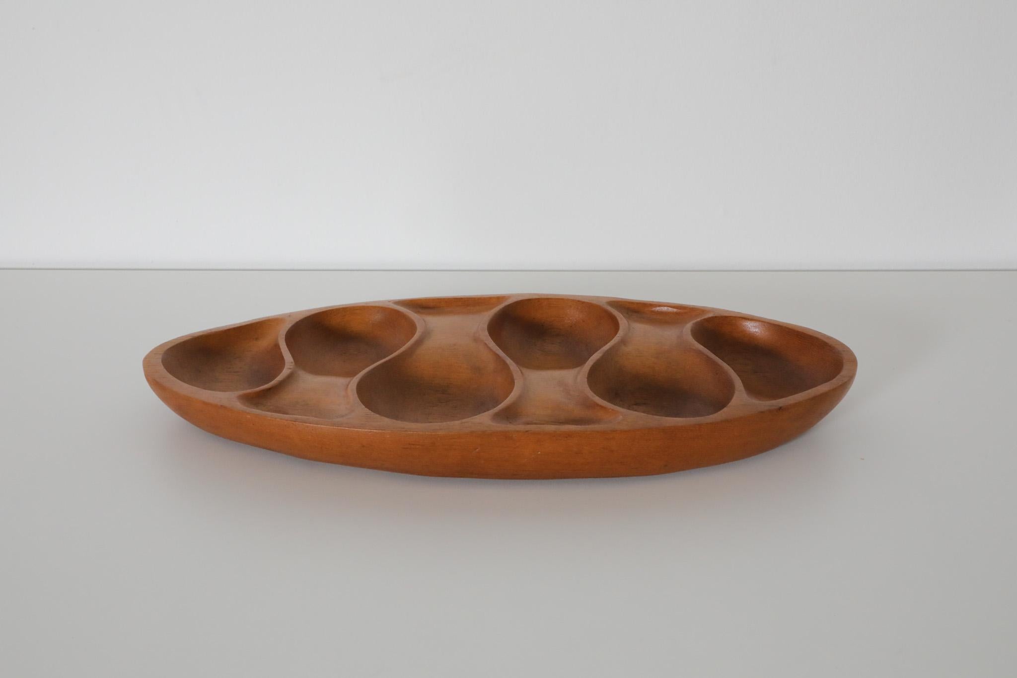 Mid-Century organically carved teak hors d’oeuvres tray with six small compartments in the style Laur Jensen for Odense. A beautiful hand carved bowl that can be used as a serving tray, jewelry organizer or accessory tray. In original condition with