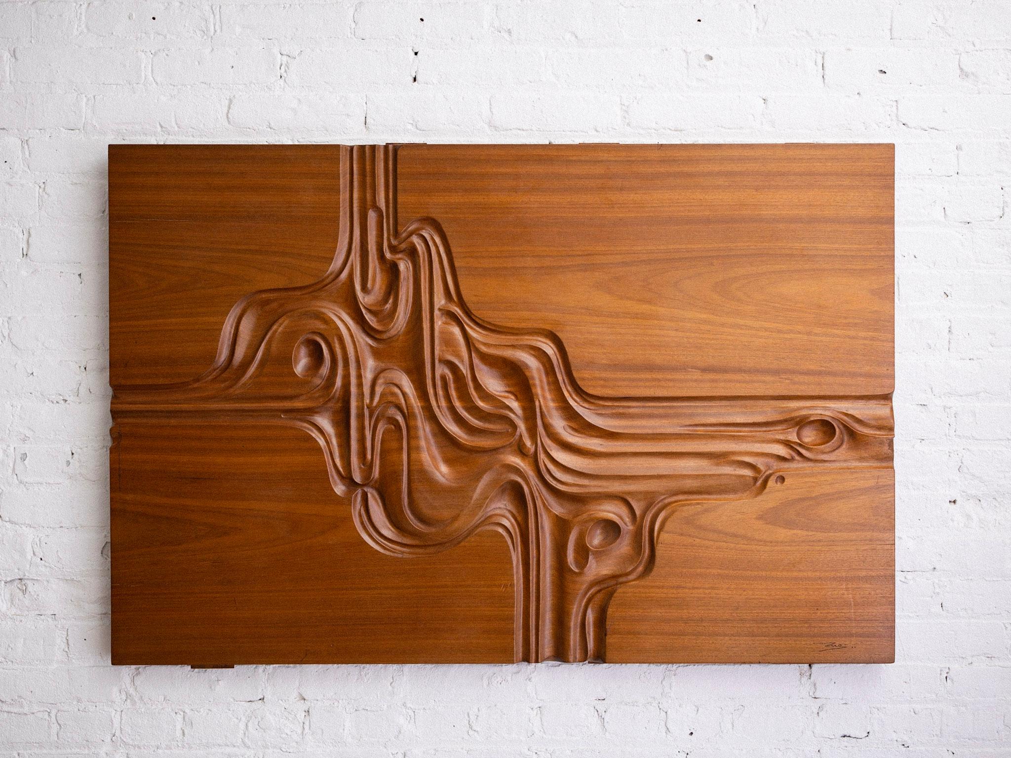 A midcentury carved wood art panel. Abstract relief carving representative of the 1970s. Back metal crossbeam for hanging. Illegible signature. Sourced in Northern Italy.