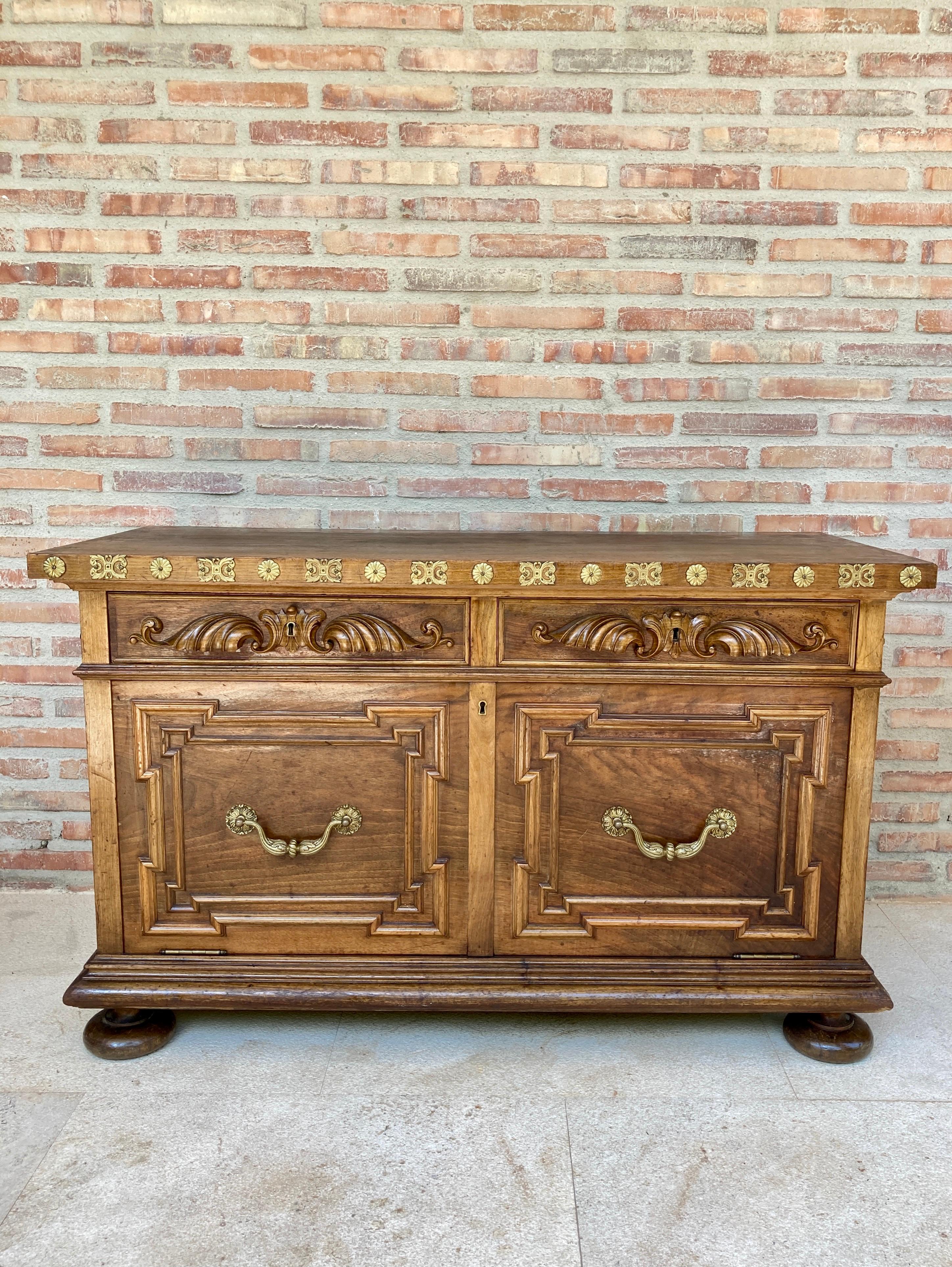 Carved wooden sideboard, with two drawers on the waist and a lower door, mid-century. With gilt bronze applications. On lentil legs. This piece of furniture has been restored. It is in very good condition It has 1 door and 2 functional drawers.