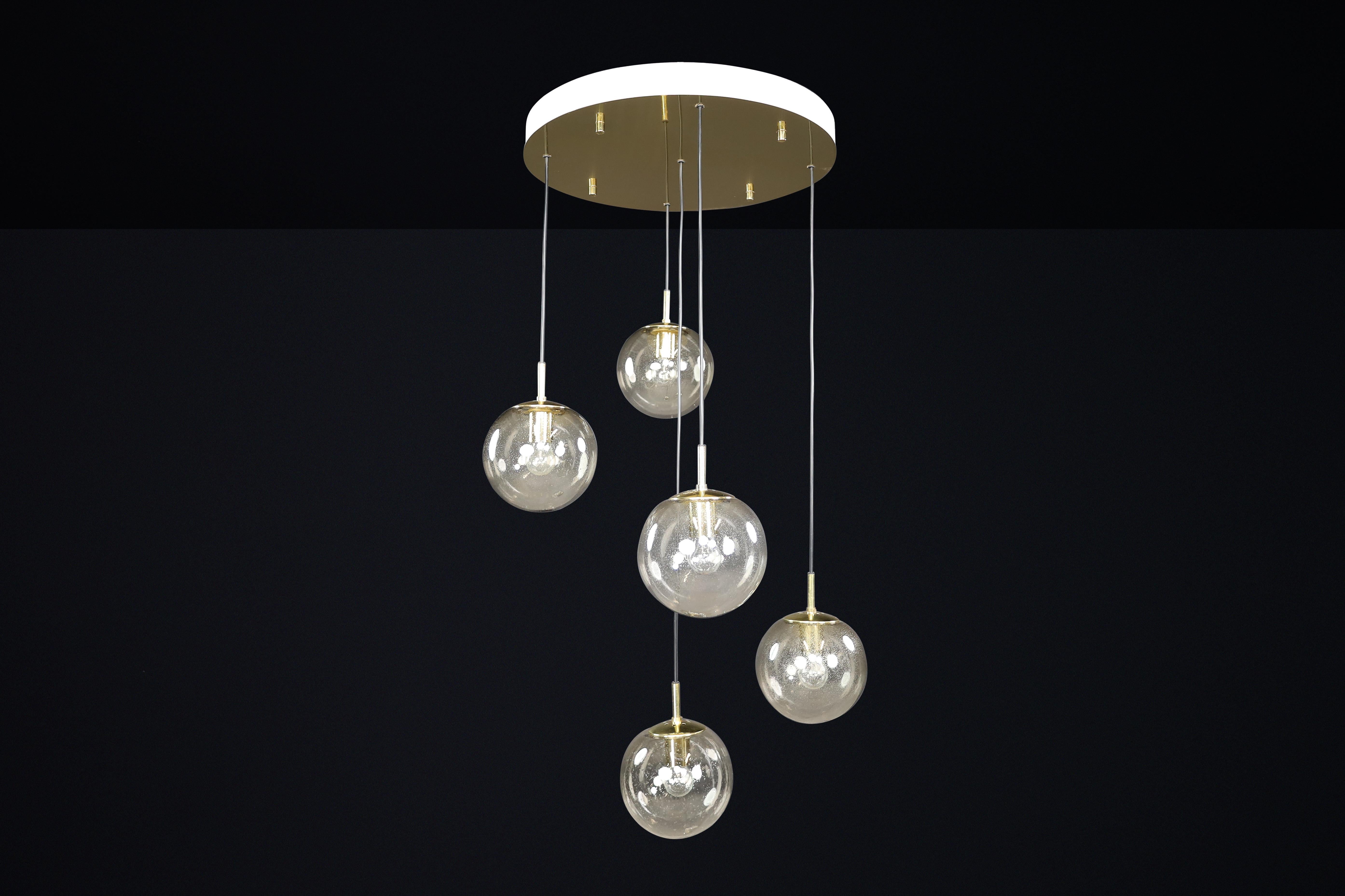 Pendentif cascade moderne du milieu du siècle avec cinq globes fumés soufflés à la main par Glashütte Limburg, Allemagne, années 1970, quatre disponibles

Ce luminaire raffiné et sculptural, cette suspension cascade de Glashütte Limburg, fabriquée
