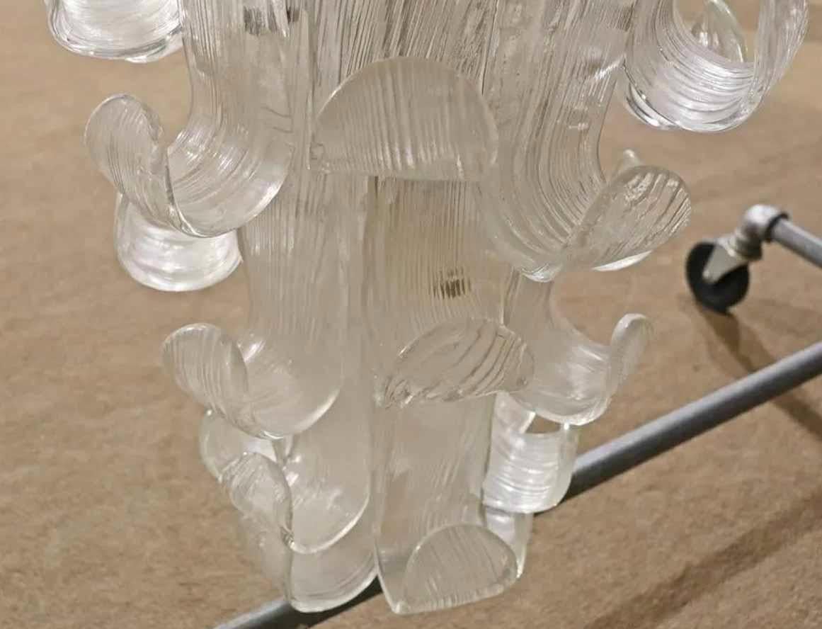 Long hanging chandelier made of feather shaped glass. Beautiful cascading effect, sure to be a centerpiece of the room.
Please confirm location.