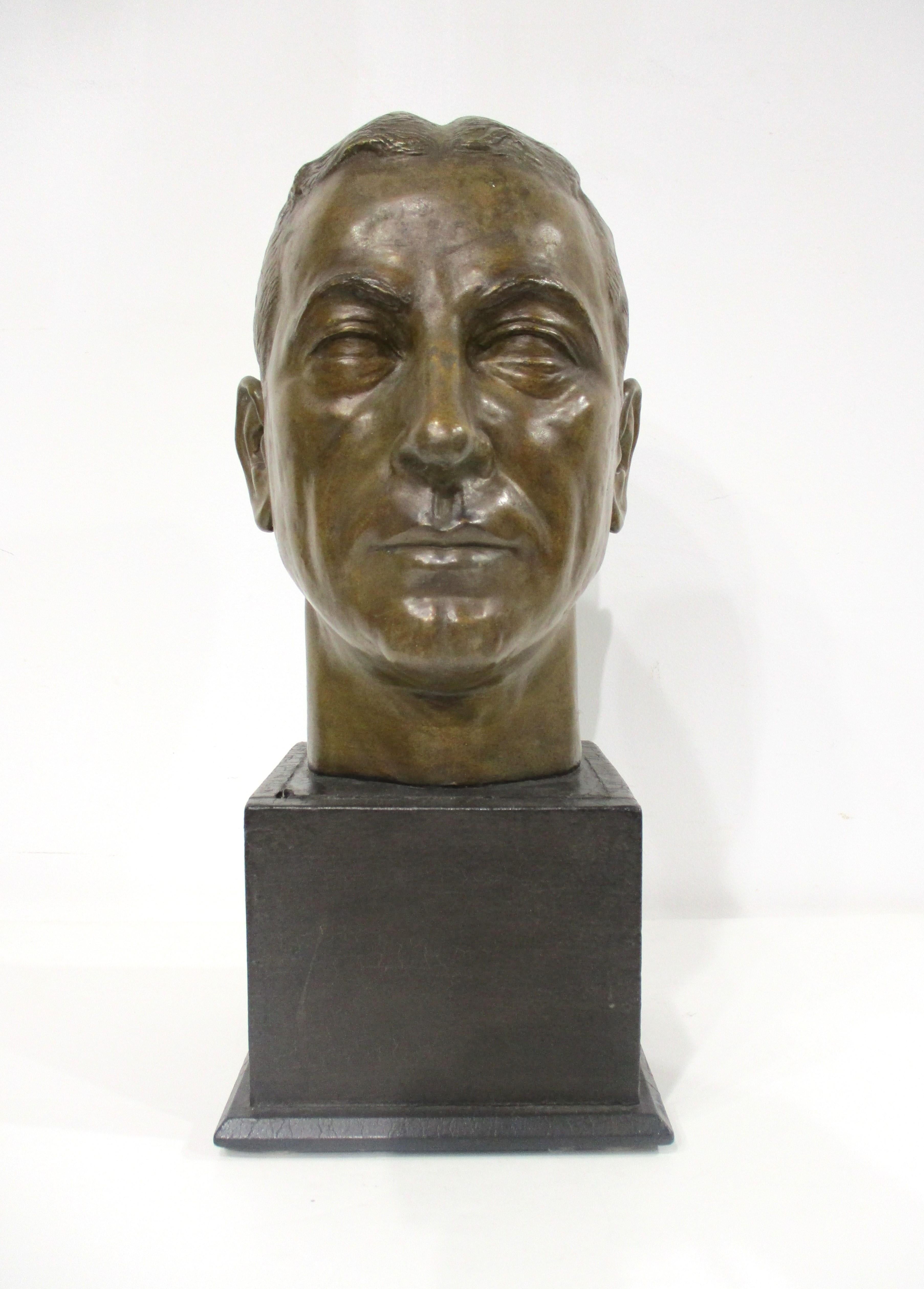 A very well crafted cast plaster mid century male head with a bronze styled toned rub which looks great . Great strong details to the face and mounted on a satin black wooden base from a unknown artist and who the bust represents . Perfect for a