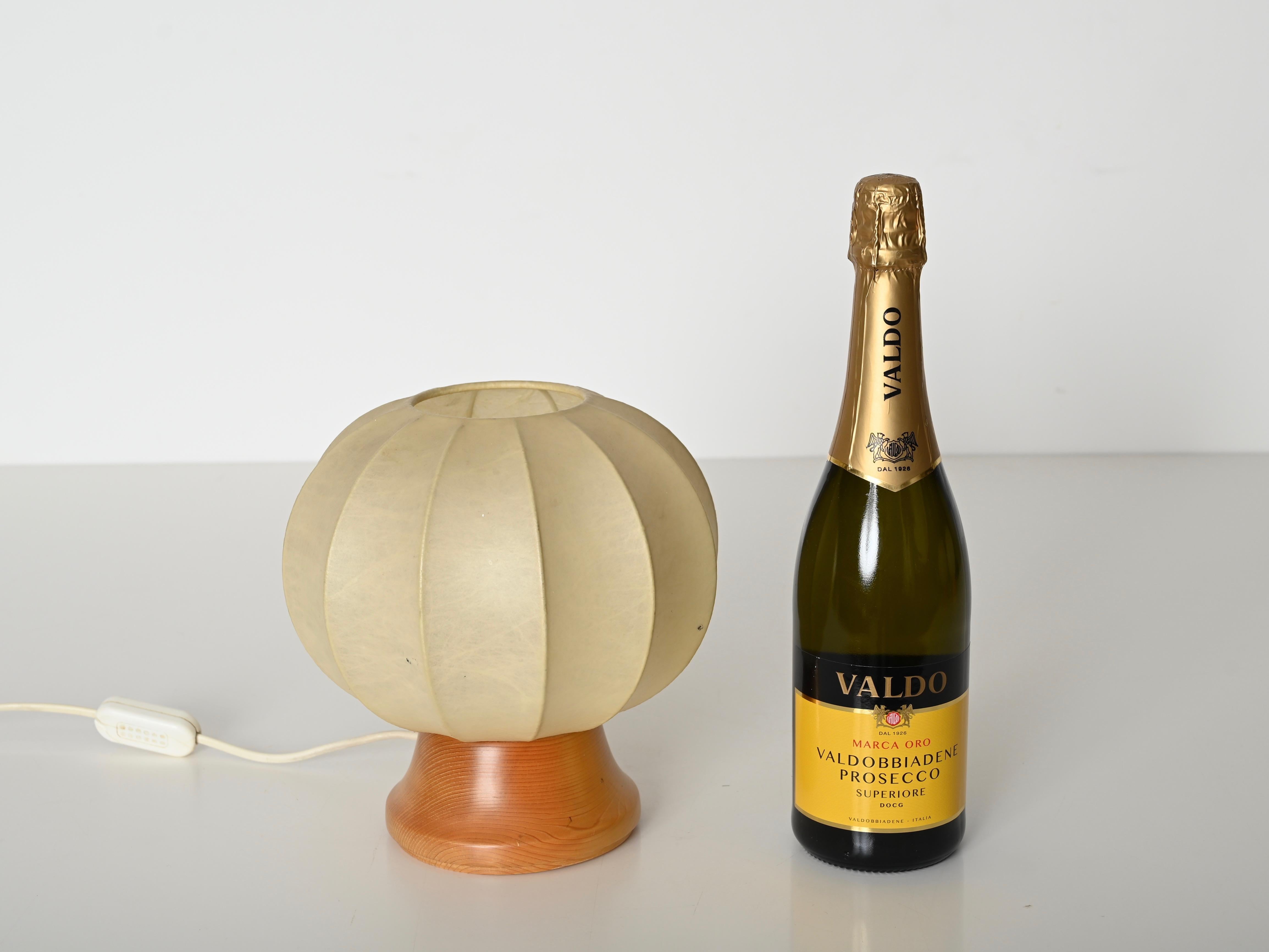 Wunderschöne Mid-Century-Kokon-Tischlampe, entworfen von Castiglioni und hergestellt in Italien in den 1970er Jahren.  

Diese stilvolle Tischleuchte hat einen runden Sockel aus Eichenholz, der durch einen beigen 