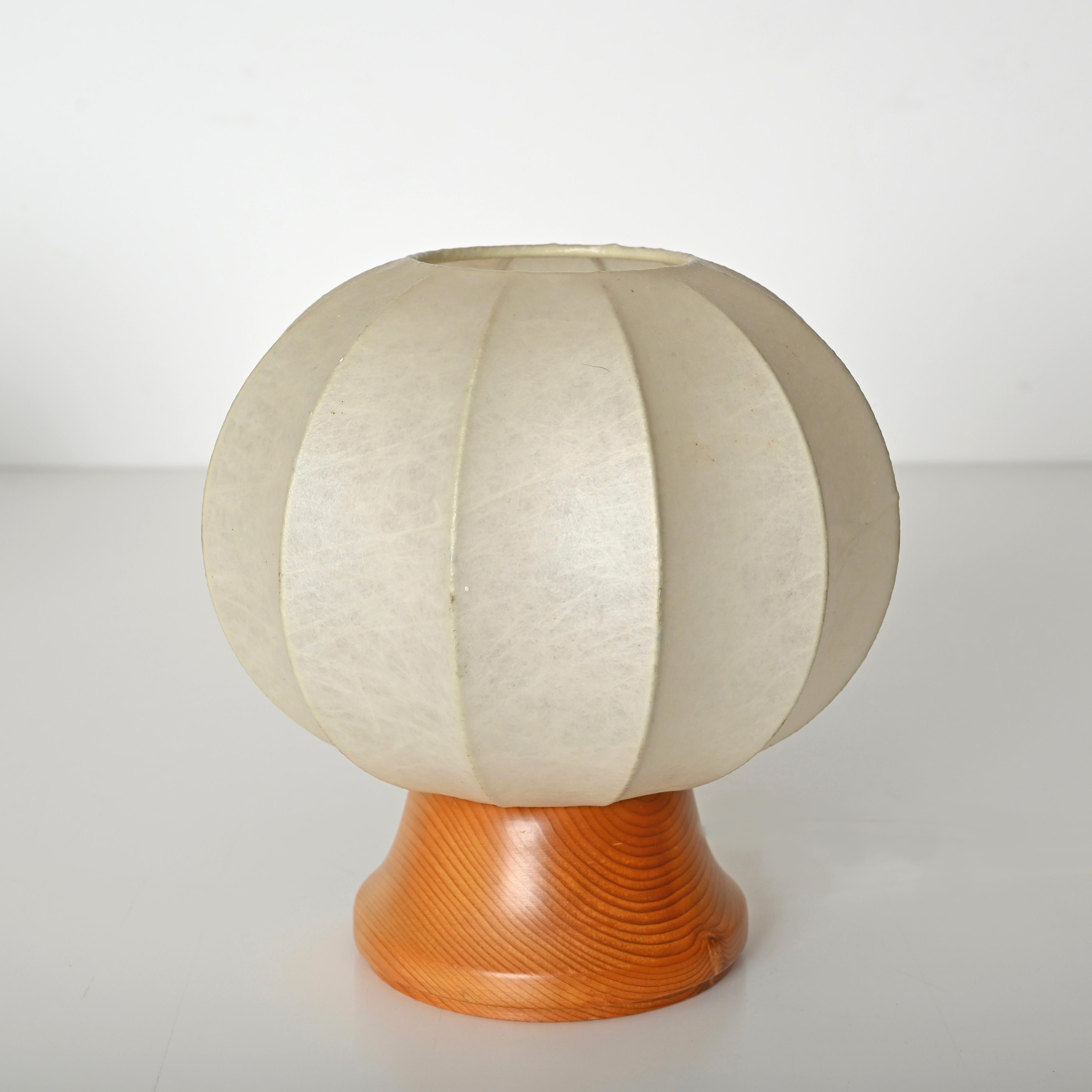 Merveilleuse paire de lampes de table cocon du milieu du siècle conçues par Castiglioni et produites en Italie dans les années 1970.  

Cette lampe de table élégante a une base ronde en bois de chêne complétée par un abat-jour beige 