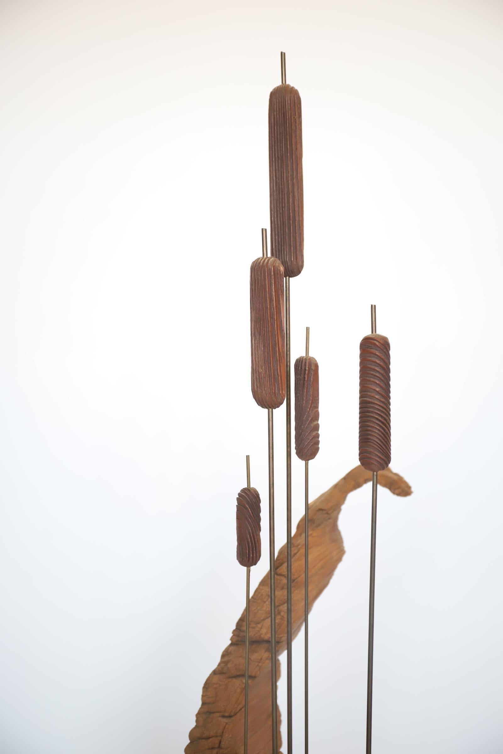 Vintage organic cattail and driftwood sculpture. Wonderfully unique and modern take on a ‘pond scene’. Cattails are composed of solid brass rods, mounted in a twisted & tiered aged piece of driftwood. Possibly a rare piece produced by Witco.