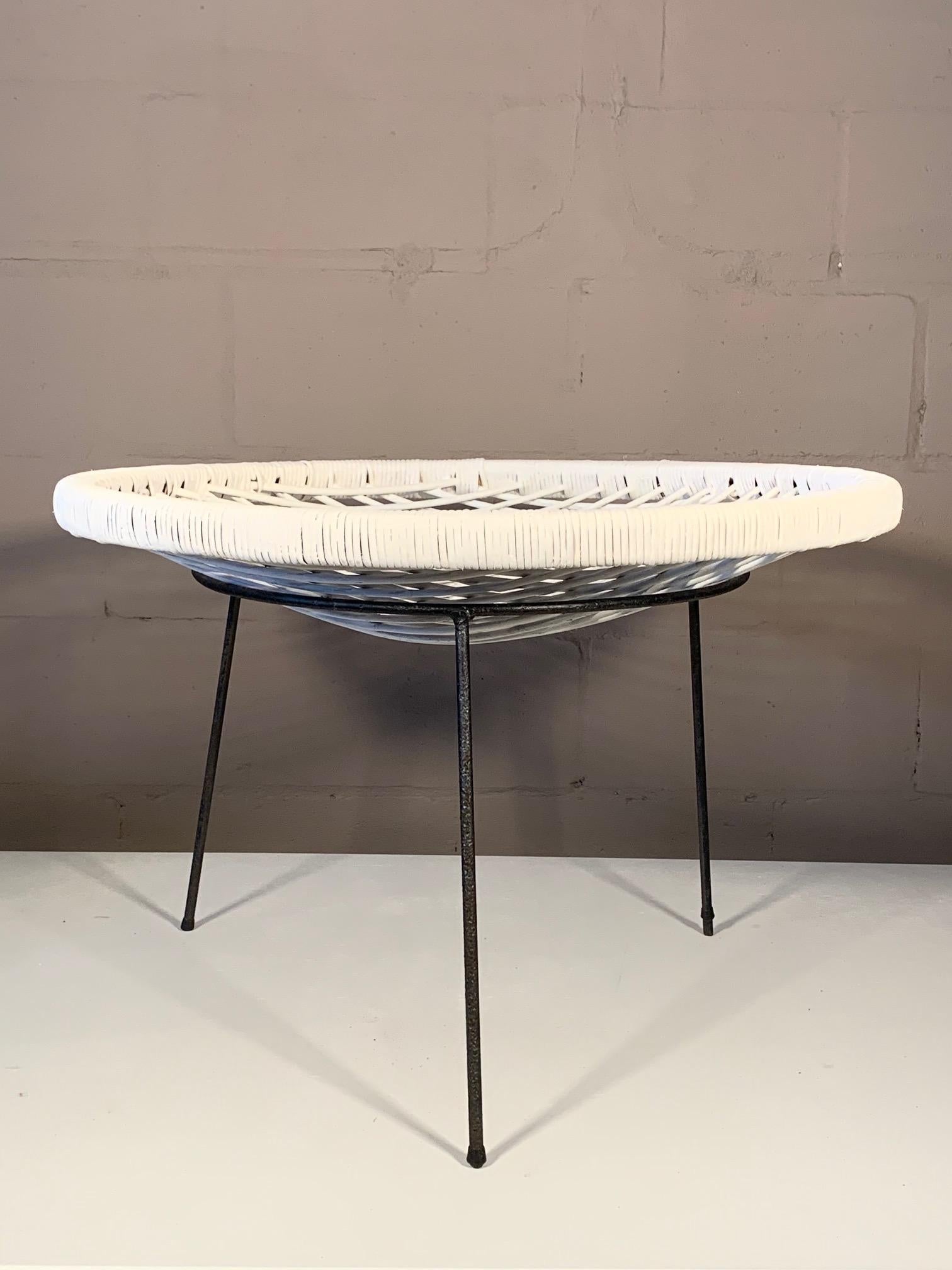 A large and unusual midcentury, circa 1950s catch all table. The rattan top, painted white, is removable.