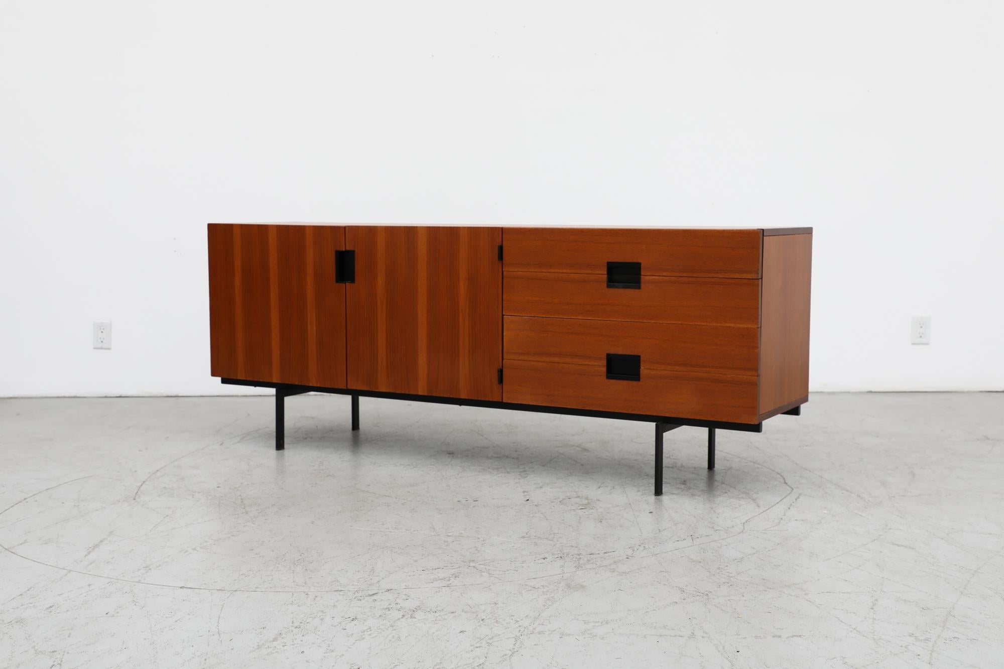 Teak Credenza with black enameled Model DU04 of the Japanese Series designed by Cees Braakman for Pastoe, 1958. This model has a delicate black enameled metal base, two cabinets and 4 stacked drawers with iconic inset handles and his signature