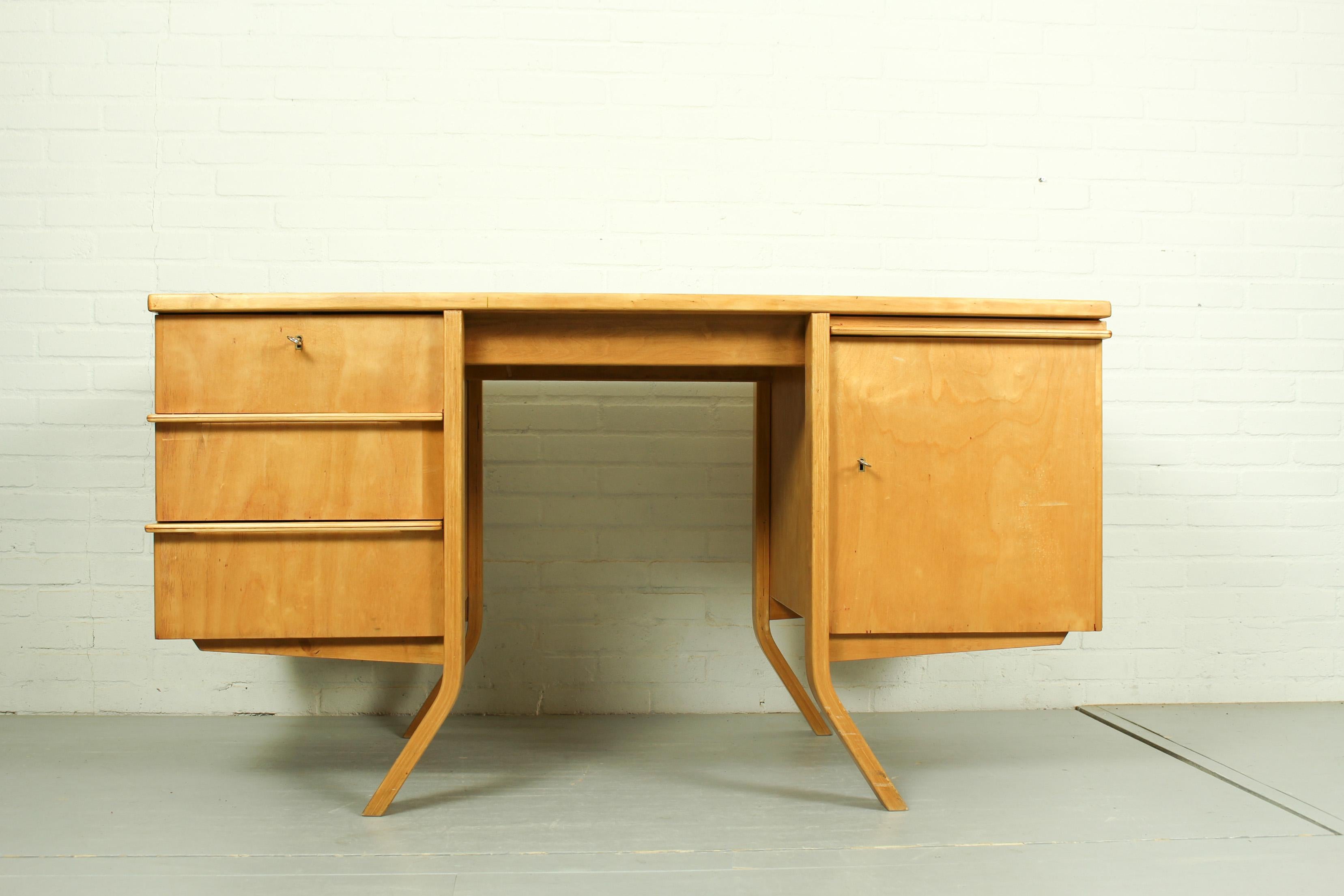 Beautiful writing desk designed by Cees Braakman for Pastoe in the early 50s. This EB04 desk is part of the ‘Birch Series’. It has 3 drawers on the left and on the right a door with 2 shelves behind and an additional working leaf above. The door and