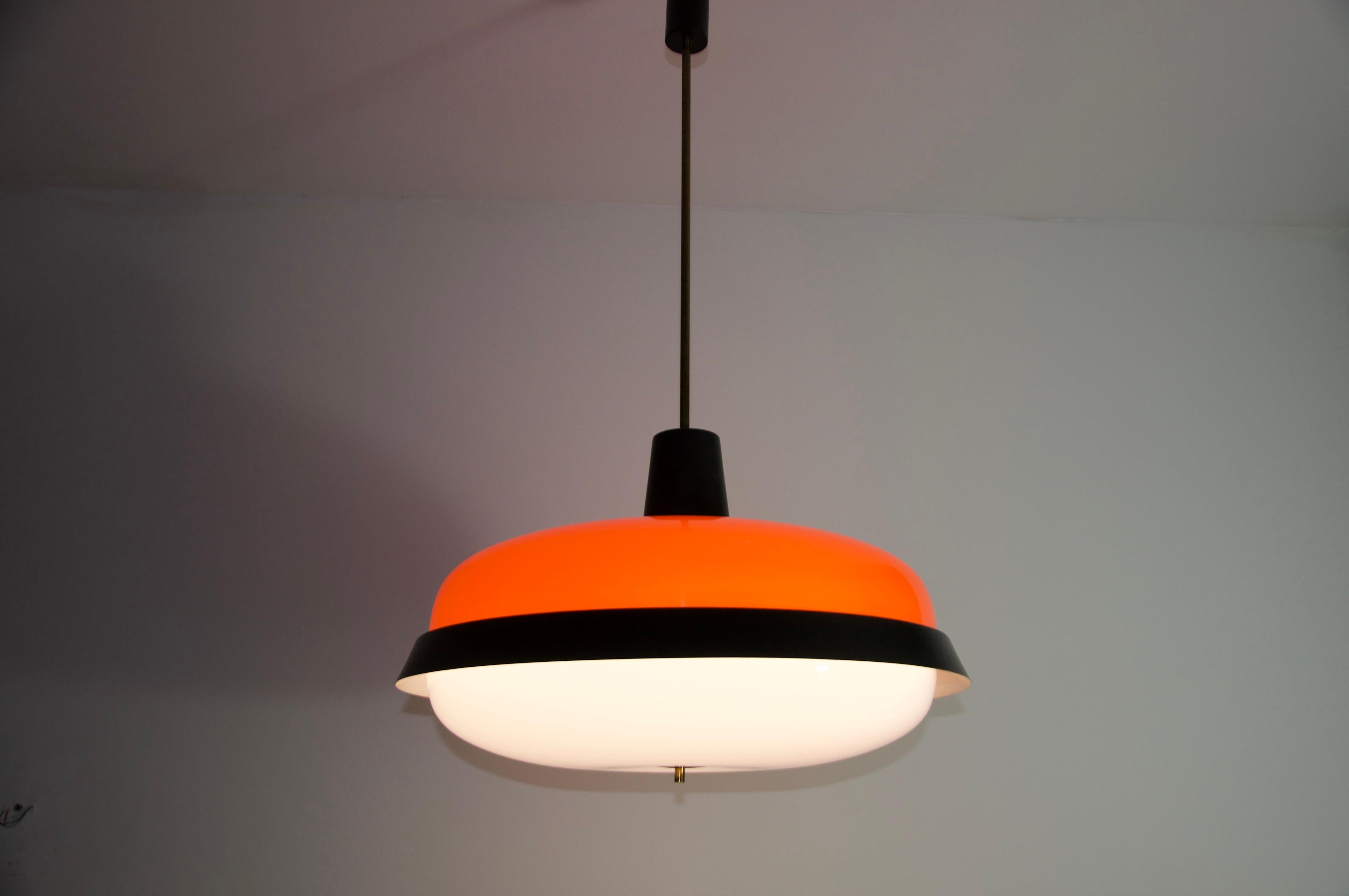 Cette lampe suspendue exceptionnelle de Stilnovo est un exemple frappant du design italien du milieu du siècle dernier. Whiting est une combinaison audacieuse de plexiglas rouge et blanc, accentuée par un élégant anneau de métal noir, qui dégage une