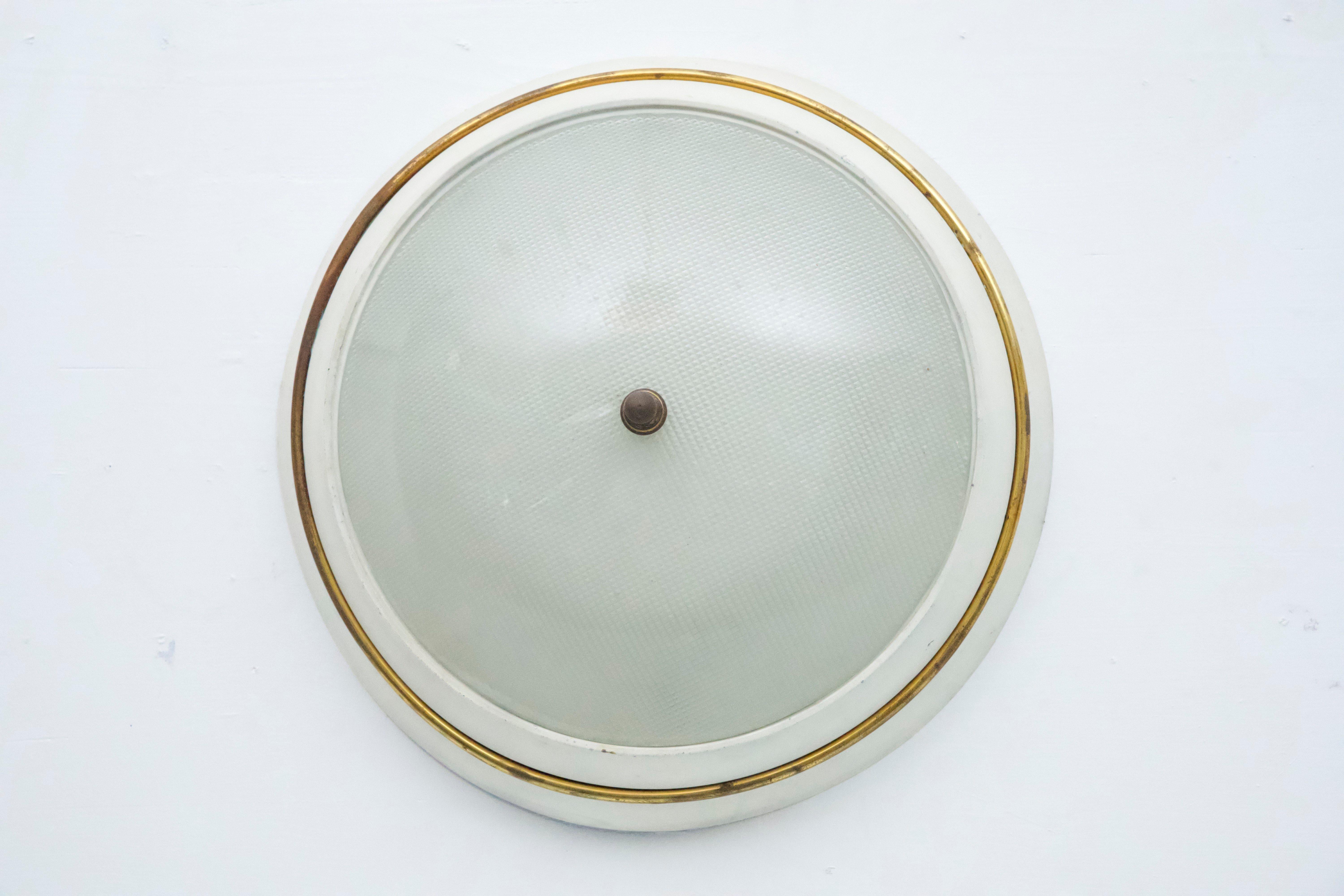 Esta lámpara de techo empotrada, fabricada en Italia en la década de 1950, está diseñada en el estilo icónico de Stilnovo. Presenta un estado vintage, con signos evidentes de antigüedad y uso que le añaden carácter y autenticidad. Funcionamiento