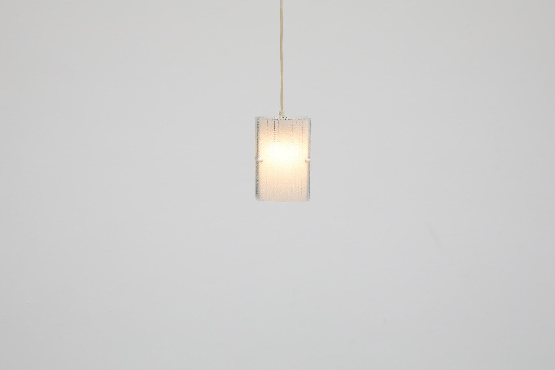 Mid-Century curved ceiling pendant with pressed, frosted glass shades with subtle pattern and black enameled panels. In original condition with visible wear consistent with its age and use. Canopy not included.