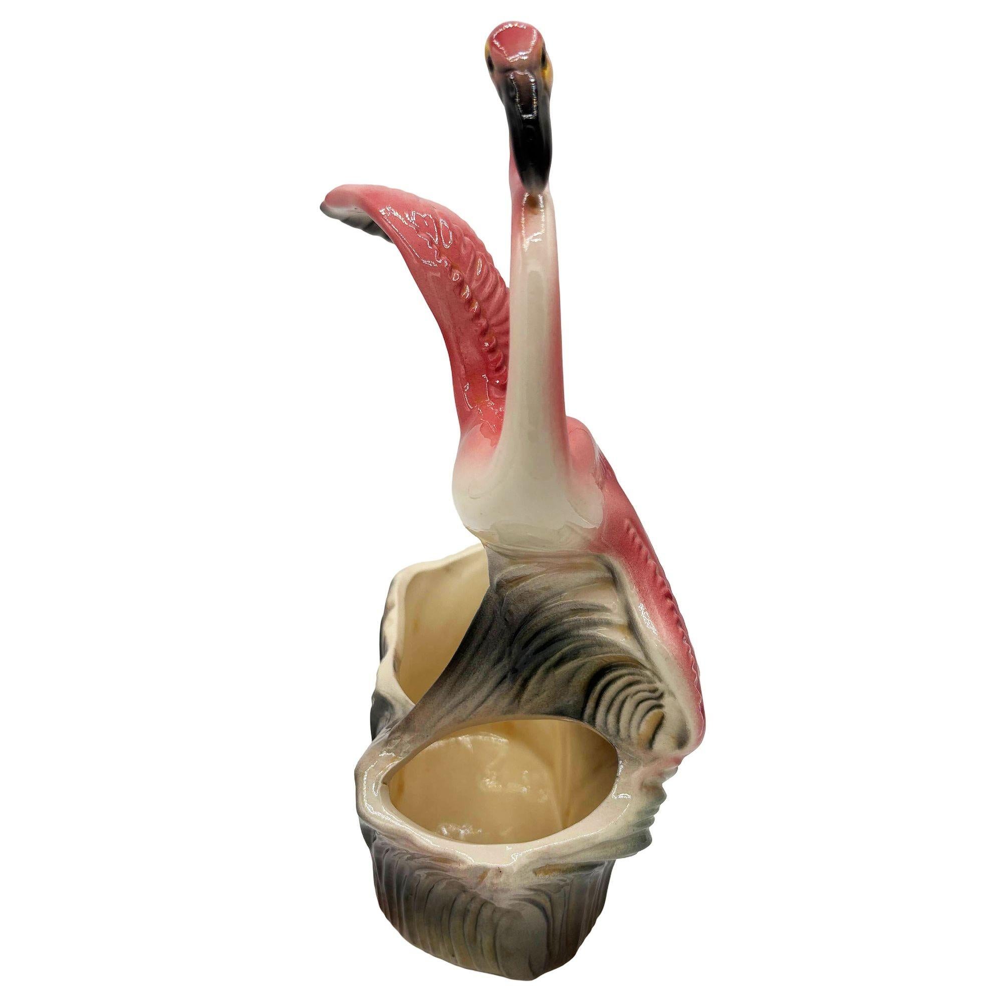 Jardinière de table flamant rose et vert en céramique du milieu du siècle California pottery tabletop planter. La jardinière représente un flamant rose magnifiquement détaillé volant au-dessus d'un champ d'herbe verdoyant. Sa finition brillante met