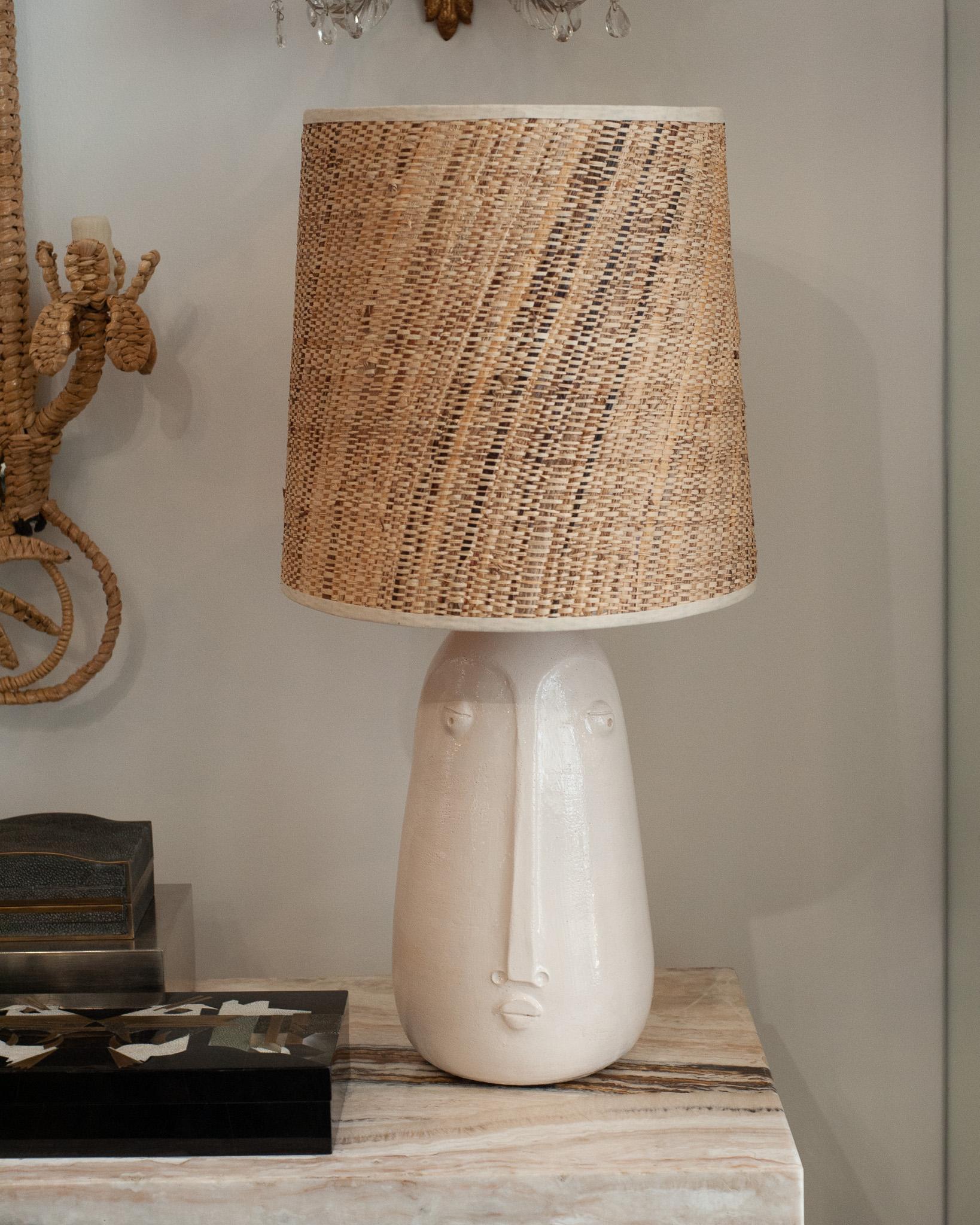 This stunning pair of Mid Century lamps features white glazed ceramic bases adorned with abstracted faces, bringing a touch of artistry and organic beauty to any room. The abstract design of the faces adds a unique, sculptural quality, making these