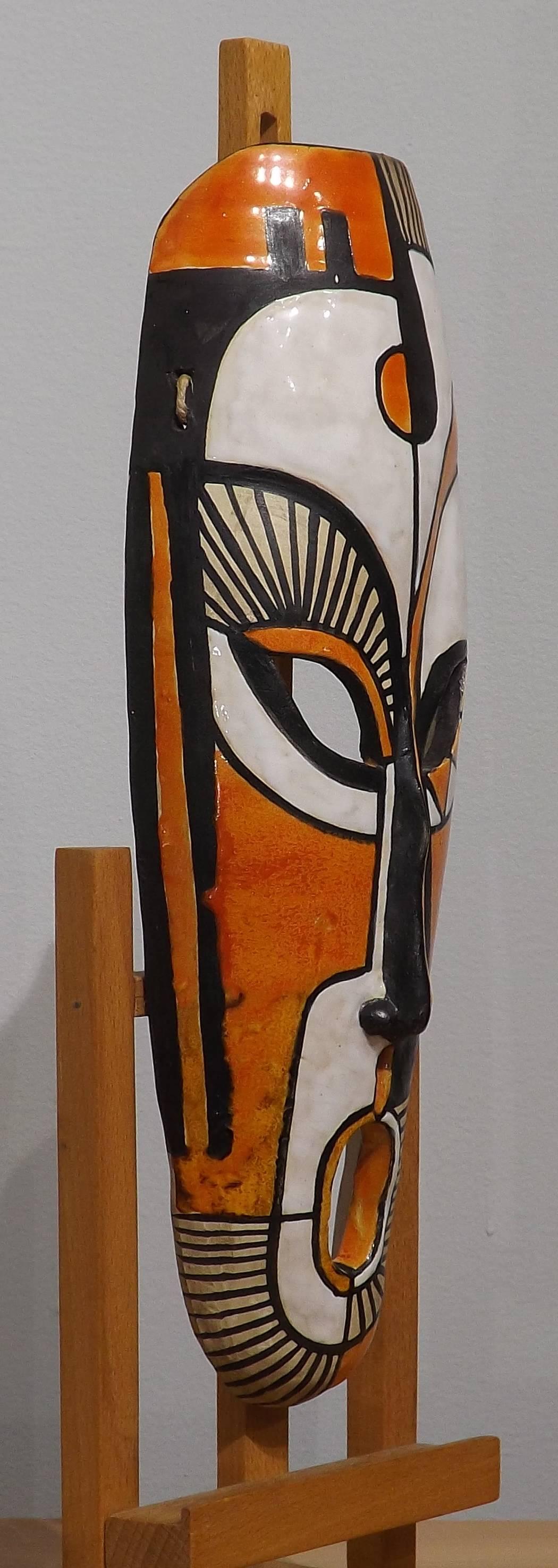 An African mask made of pottery, decorated in abstract patterns in white, black and white. Dated 1955 and initialized 'GL'. Most likely of French origin.
