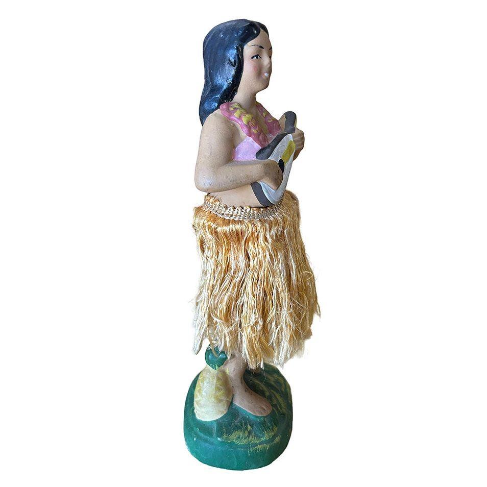 Original post-war ceramic chalkware dancing Hawaiian Hula girl figurine made from lightweight plaster and painted in vibrant tropical colors and a fabric hula skirt. It depicts a young Hawaiian hula dancer in traditional attire, posed in a hula