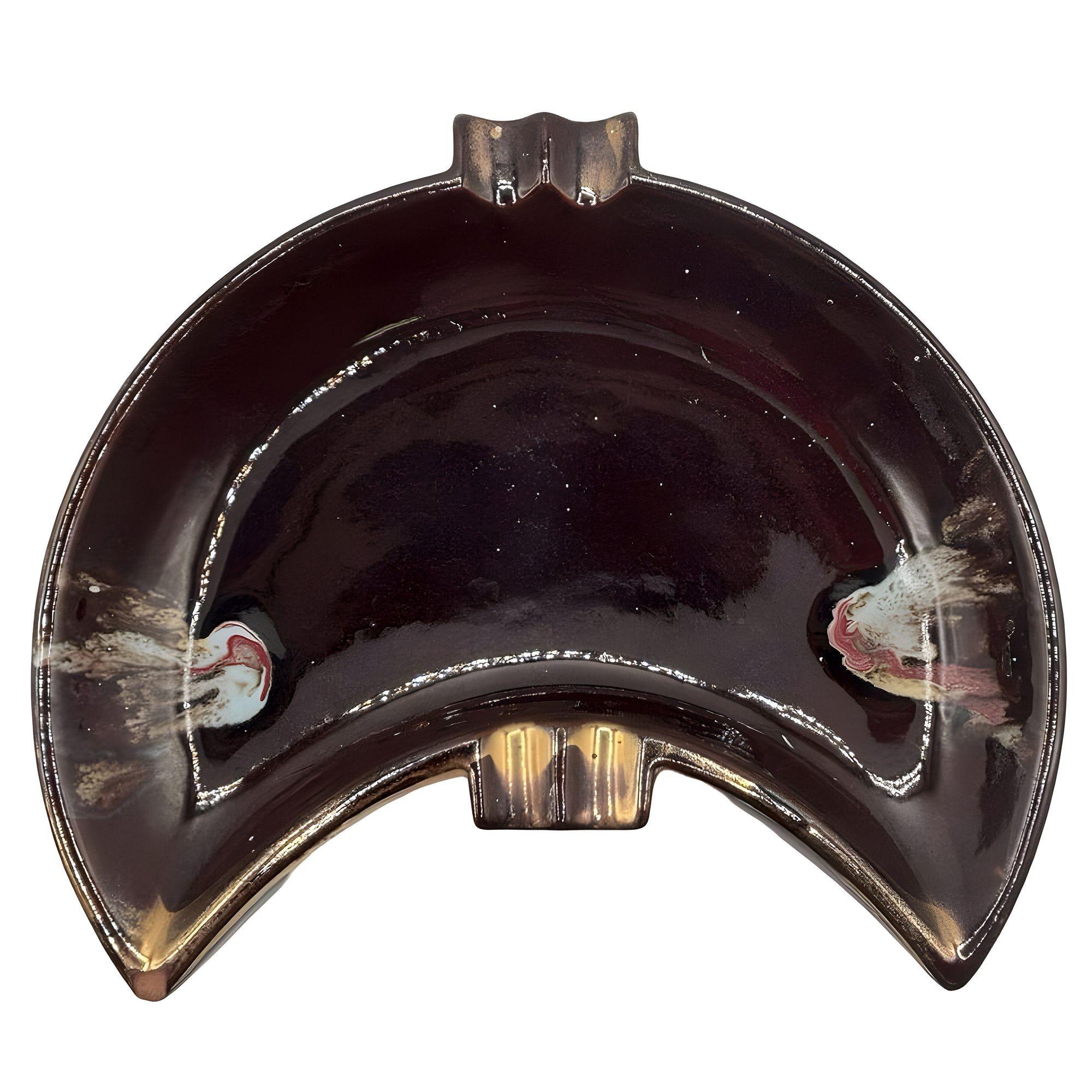 Cendrier en forme de croissant, de couleur marron, avec des accents dorés et multicolores, datant du milieu du siècle. La riche glaçure brune met en valeur sa forme sculpturale, ajoutant chaleur et sophistication à son esthétique. Bien pensée, sa