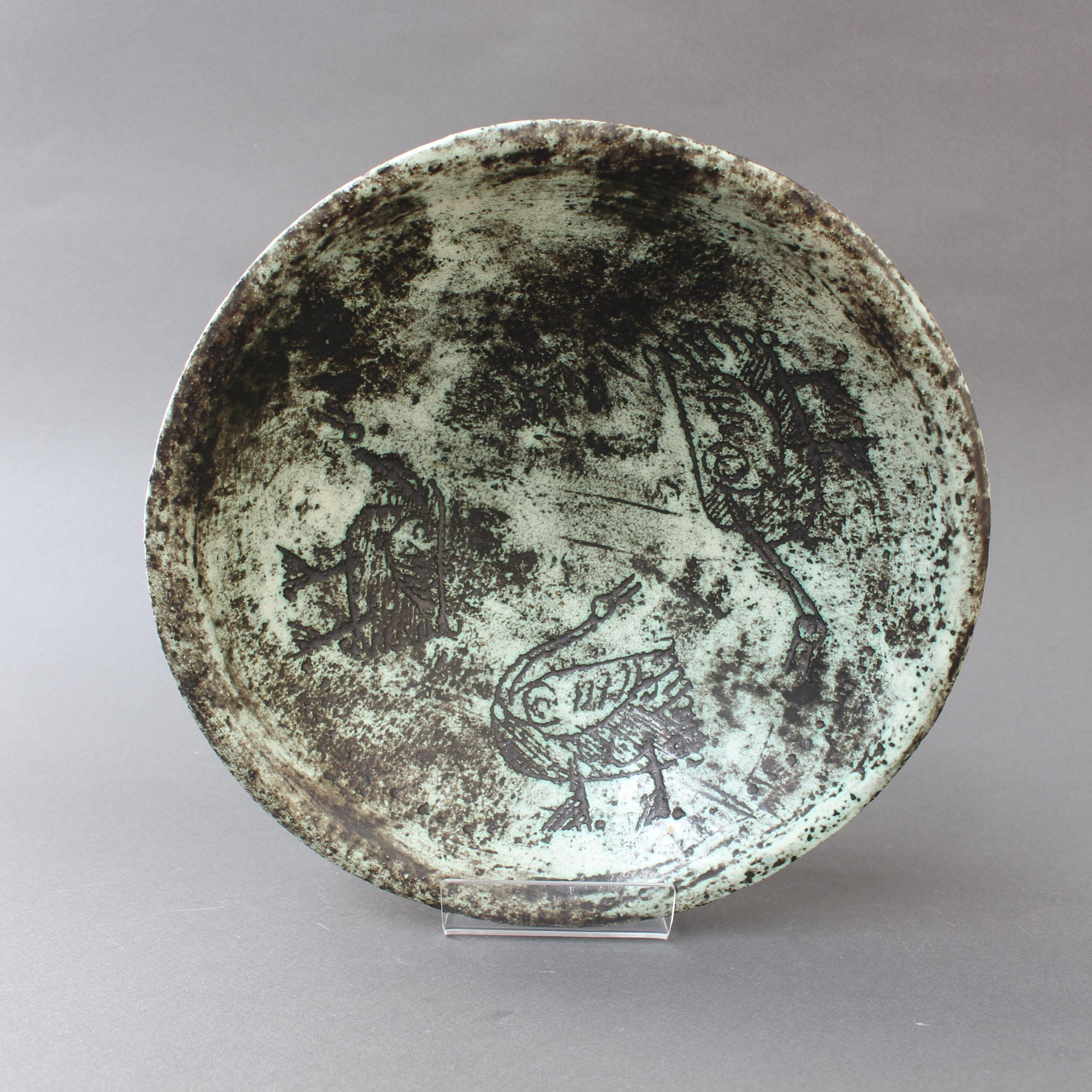 Midcentury ceramic decorative bowl by Jacques Blin (circa 1950s). Created in Blin's trademark misty glaze, this elegant bowl is incised with birds which may have just been discovered in an ancient cave filled with art. Its medium size means it would