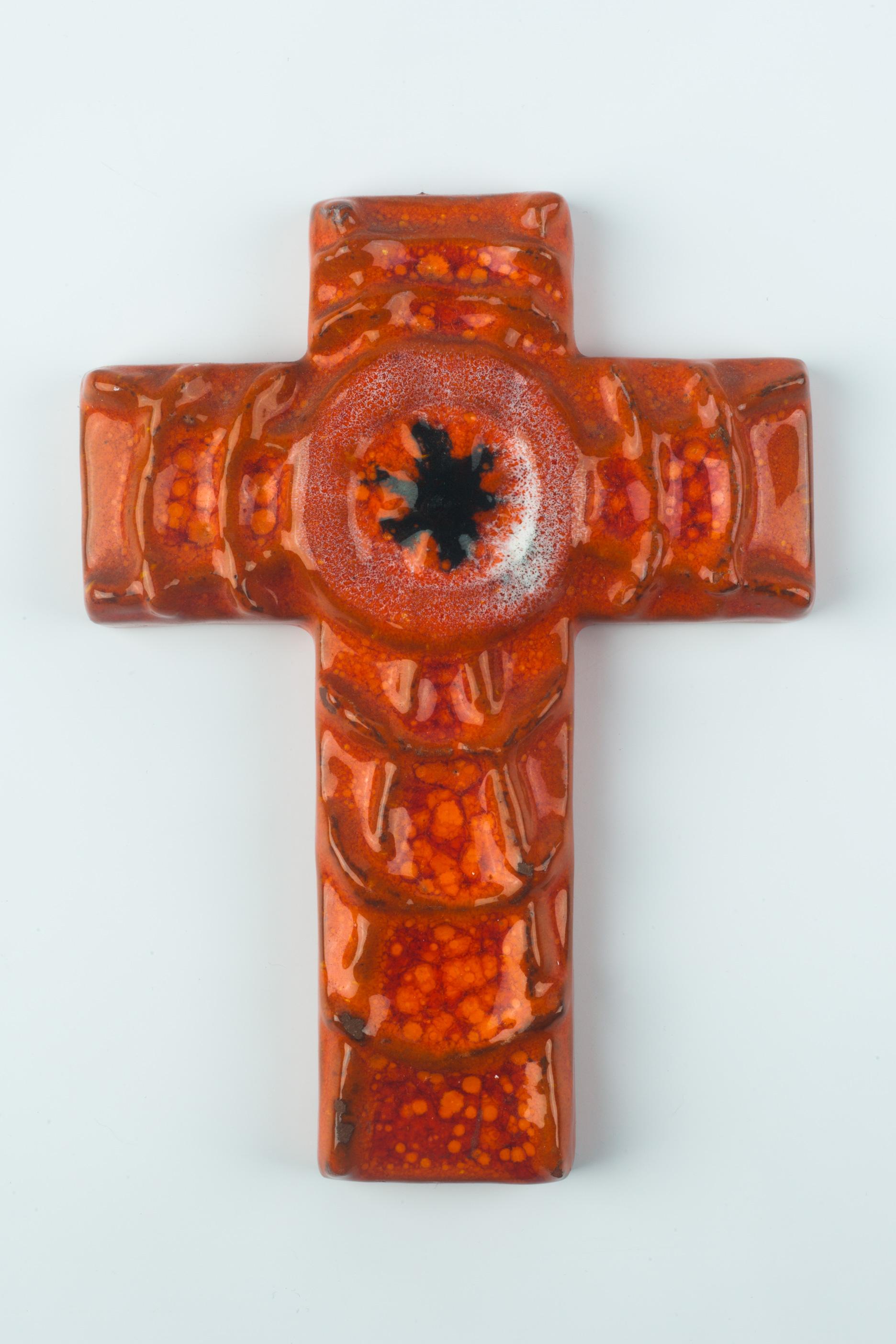 Mid-century, European ceramic crucifix hand-painted in orange, yellow and red with a black spider-like figure at its center, and white coloring surrounding it. Unusual spider web design in volume throughout the cross. A one-of-a-kind, handcrafted