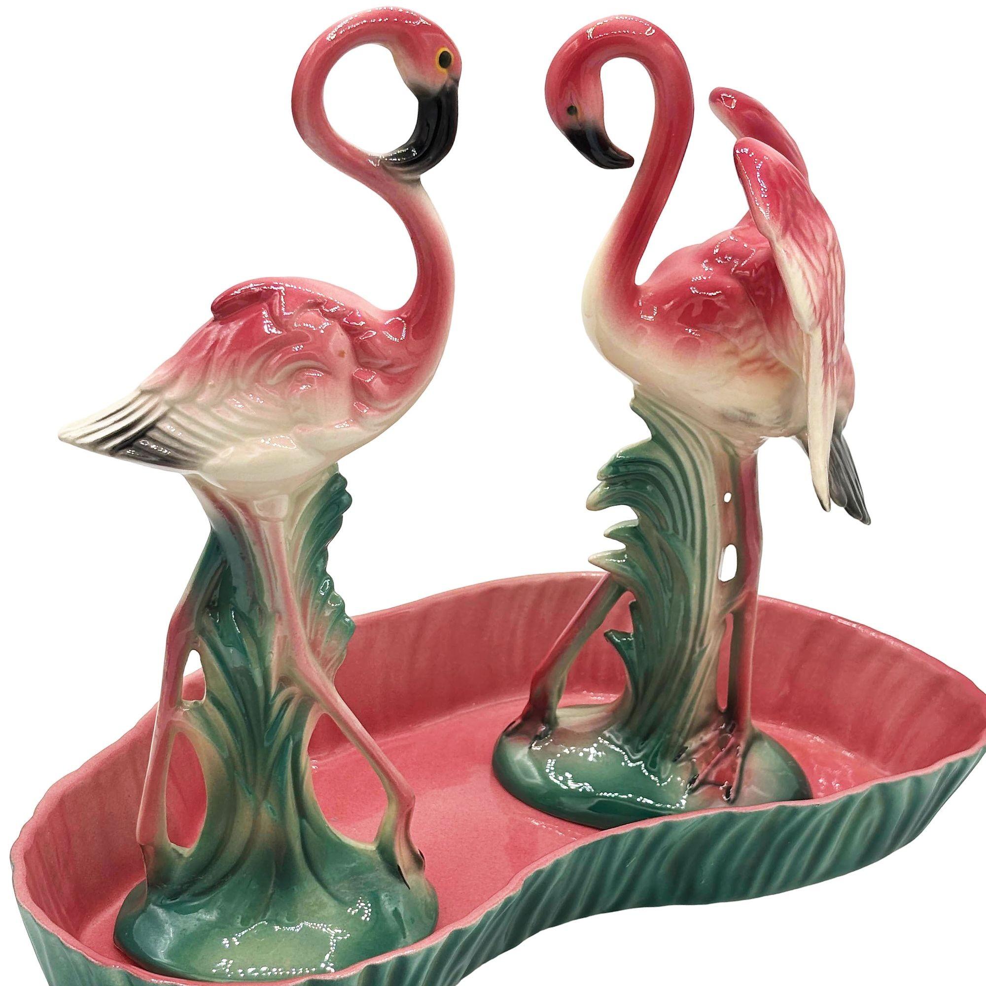 Mid-century set of 2 pink and green flamingo ceramic figurines with flamingo pool tray decorative bowl. The set features two beautifully detailed pink flamingos with wings outstretched among lush green leaves, and a matching pool tray featuring a