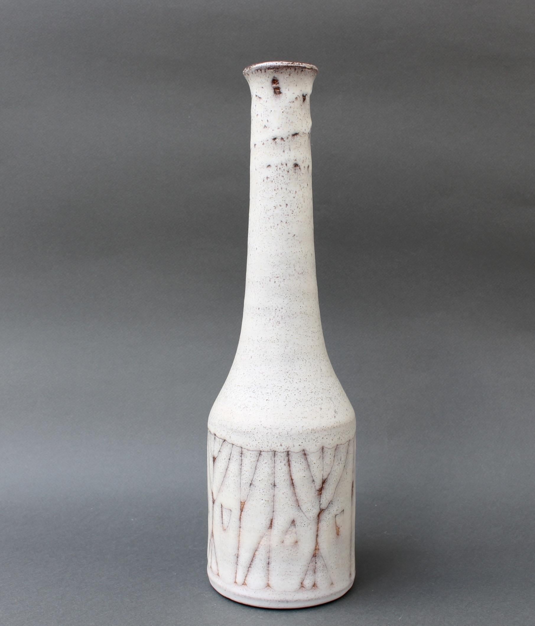Midcentury ceramic flower vase (circa 1960s) by Jacques Pouchain, telier Dieulefit. This elongated sculptural flower vase is both beautiful and utilitarian. The neck is milk-white with variegated surface - brown speckles at the top reducing in size
