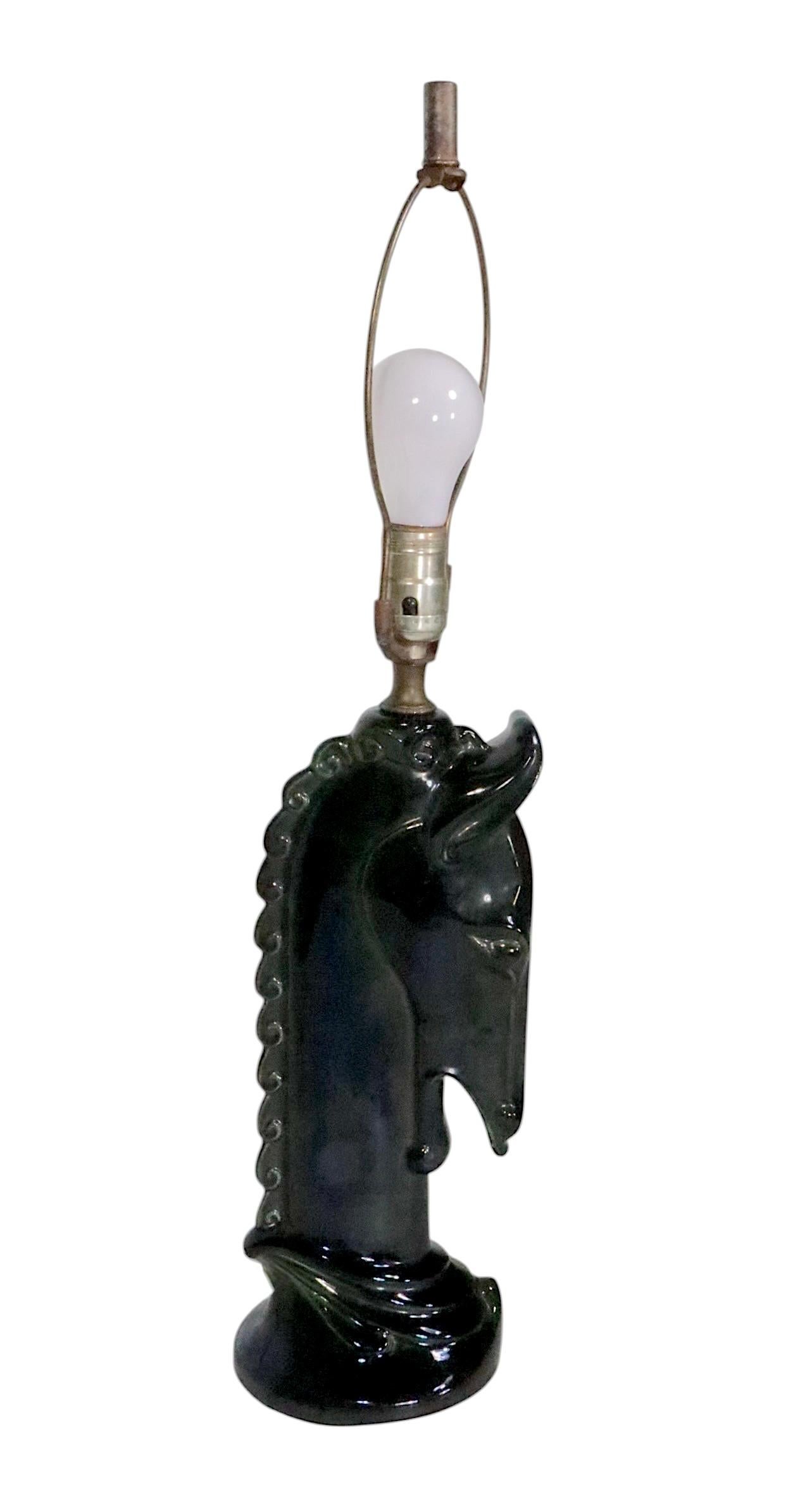 Regazo de mesa de cerámica de mediados de siglo en forma de cabeza de caballo estilizada, ejecutado en negro de alto brillo, con tintes verdes, vidriado. Este ejemplar está en muy buen estado, original, limpio y listo para su uso, mostrando sólo un