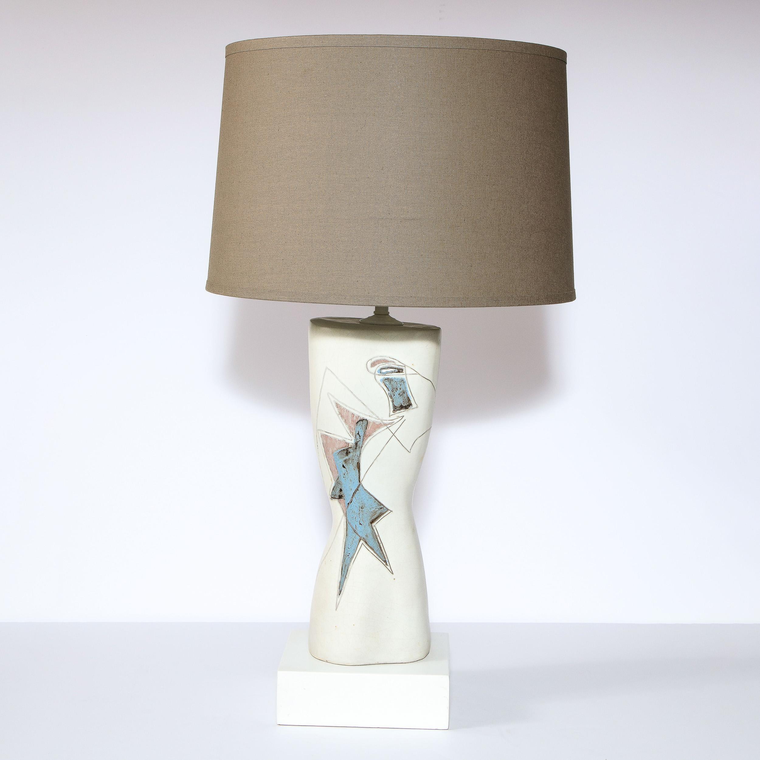 This elegant Mid-Century Modern lamp was realized and signed by the esteemed designed Marianna Von Allesch, in the United States circa 1950. Sitting on a white volumetric rectangular base, the lamp features an atomic form body in white ceramic with