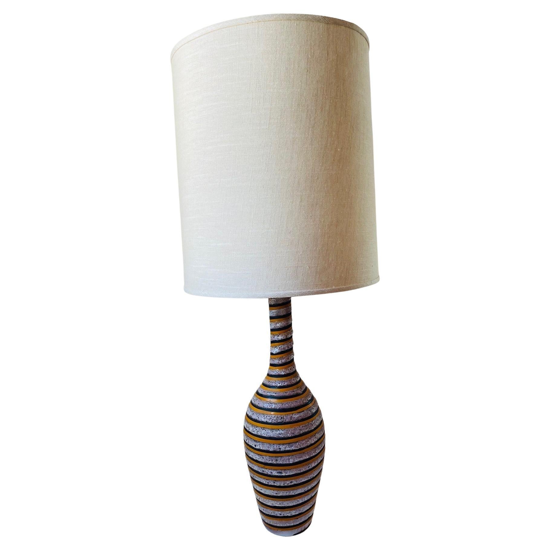 
Outstandingly stylish and rare lamp by Bitossi, made in Italy ca' 1960's. Beautifully crafted by hand, this piece is a work of art elements. Painted swirl strokes of orange brown, contrasting with bulbous texture and volcanic glaze. Simply unique