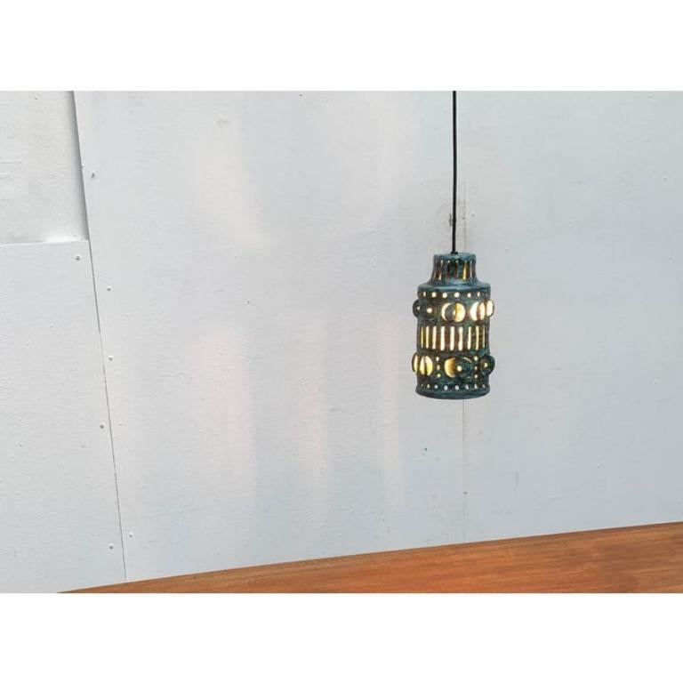 Rara lampada a sospensione in ceramica.

Una luce funzionale e allo stesso tempo un oggetto imponente. Lo schermo cilindrico si assottiglia verso l'alto. Si aggira in modo circonferenziale dalle aperture. Questi sono progettati come fori e fessure