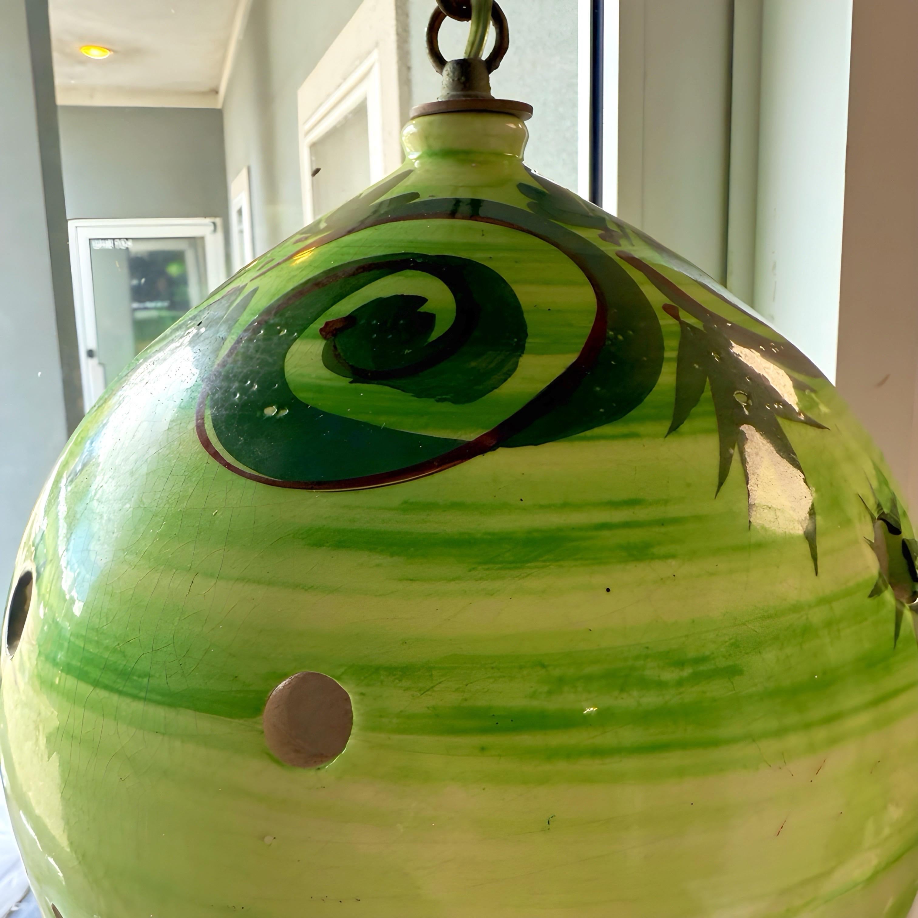 Lampada a sospensione in gres della metà del secolo scorso, proveniente dalla Germania. La superficie della ceramica è di un bel verde strutturato a più tonalità. I cerchi traforati creano ombre e movimenti meravigliosi sulla parete. Questa lampada