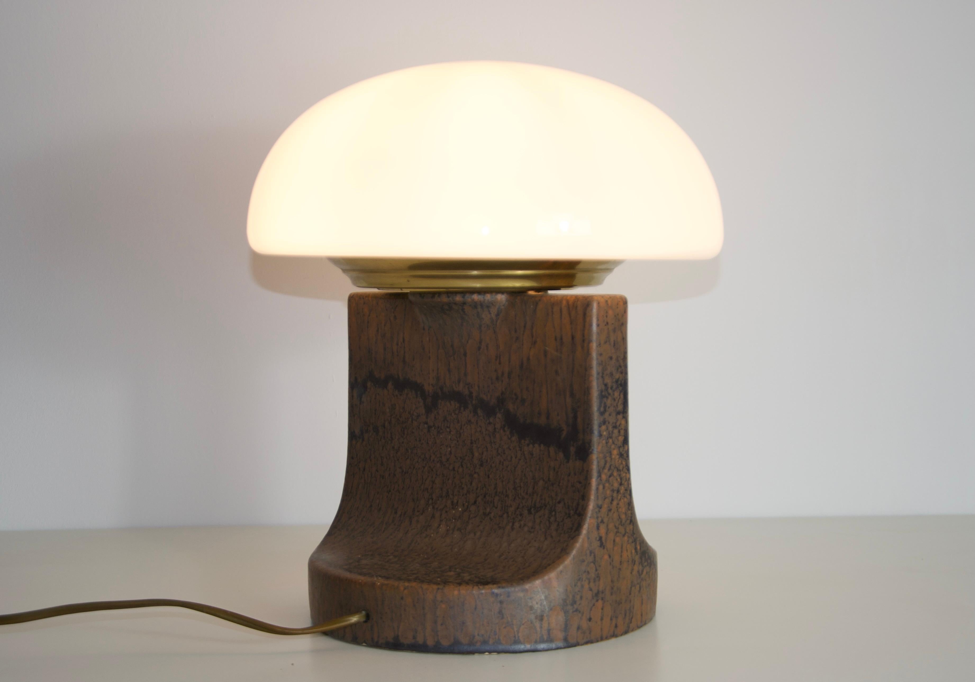 Questa splendida lampada da tavolo italiana degli anni '60 incarna l'eleganza e la maestria del design di metà secolo. La base è realizzata in ceramica di alta qualità, con una texture ricca e una forma organica che aggiunge calore e profondità a
