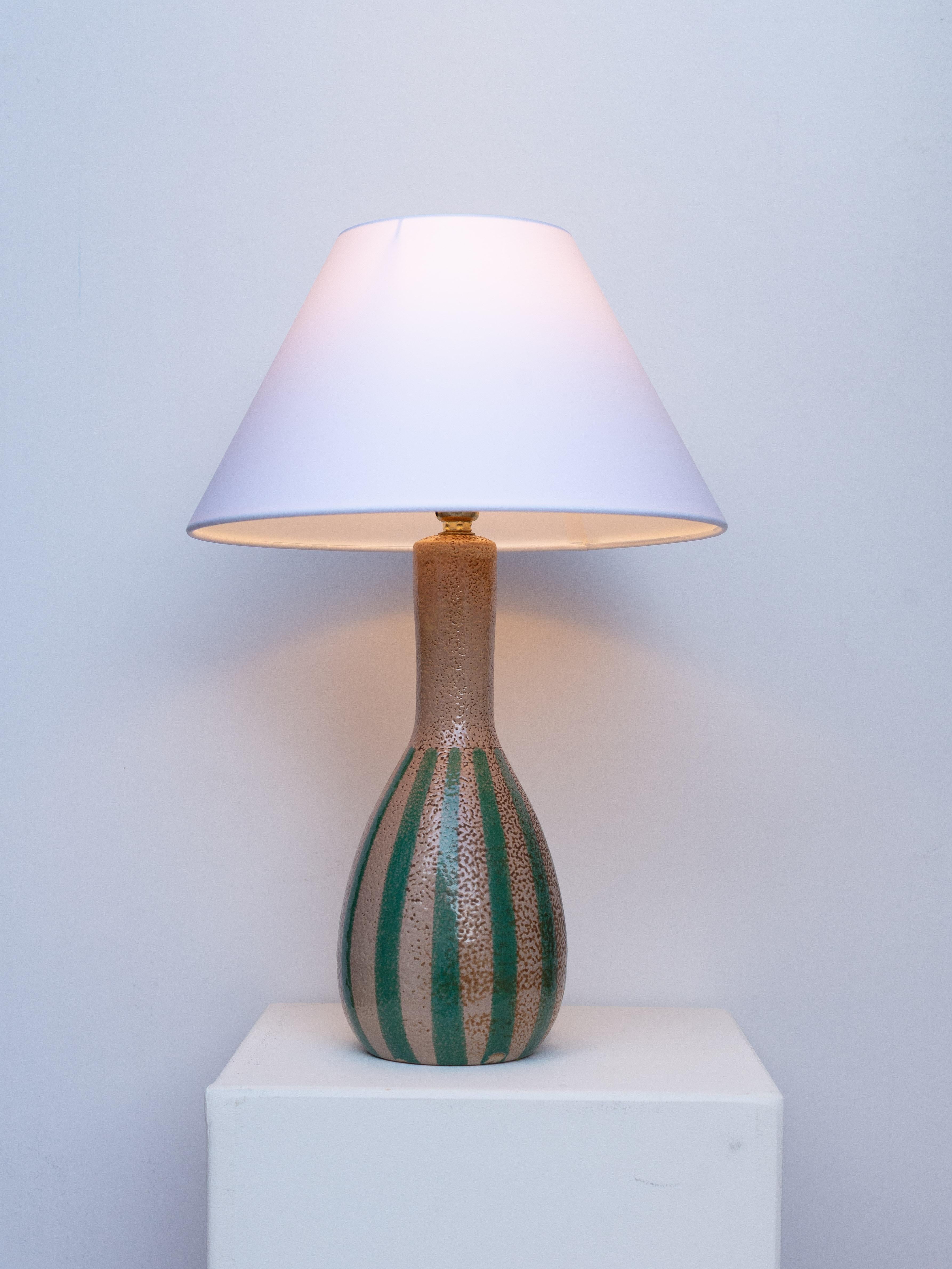 Lámpara de sobremesa de cerámica de mediados de siglo - Esmalte a rayas marrón y verde - Bélgica, años 60

Rara y elegante lámpara de cerámica belga de los años 60 que presenta un motivo de rayas verticales poco común, creado mediante bandas